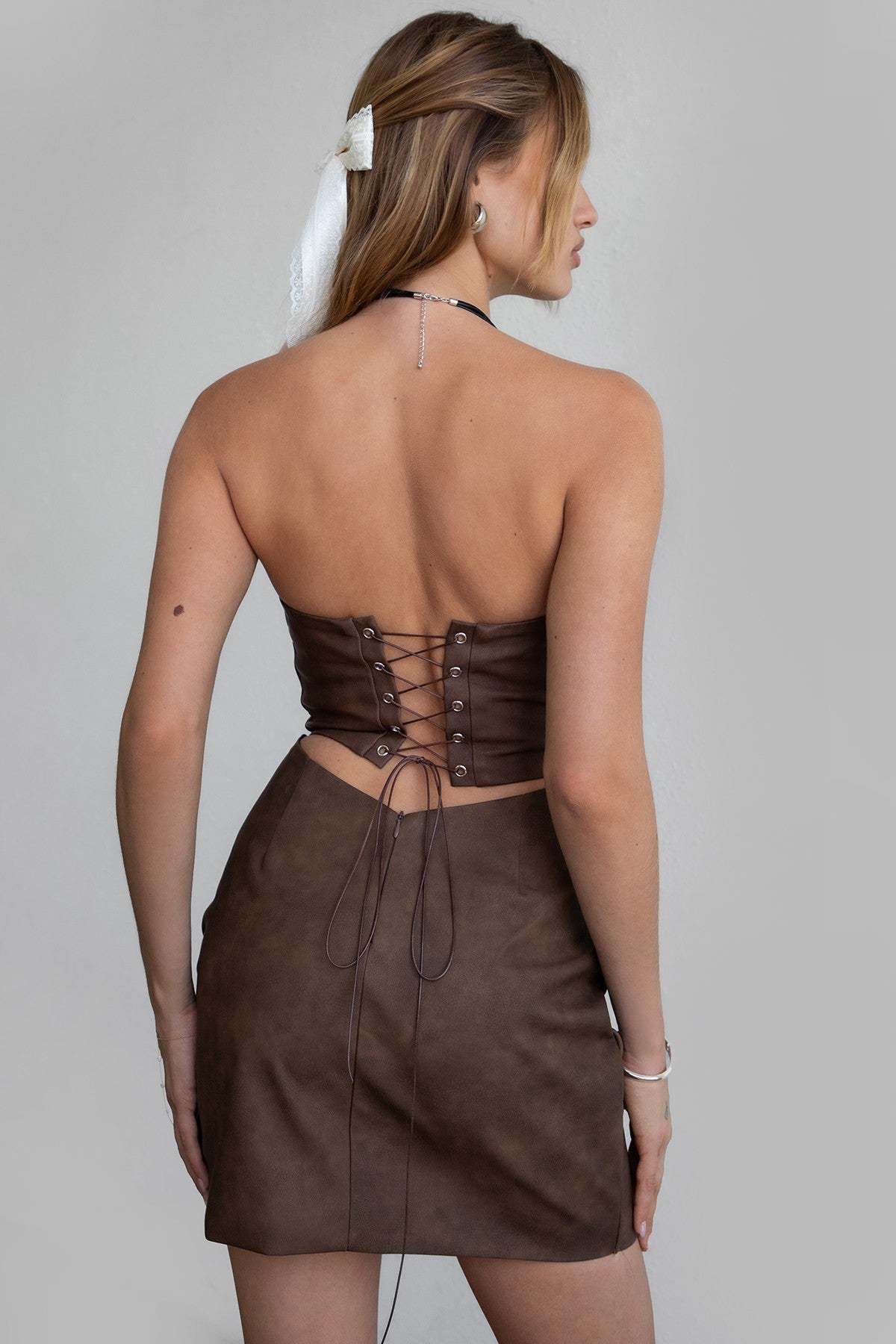 TIC TOC DA30447 ARIZONA Embroidered Western Mini Dress. A strapless PU vegan leather mini dress with a sweetheart neckline, open back lace-up tie, and Western-inspired embroidery.