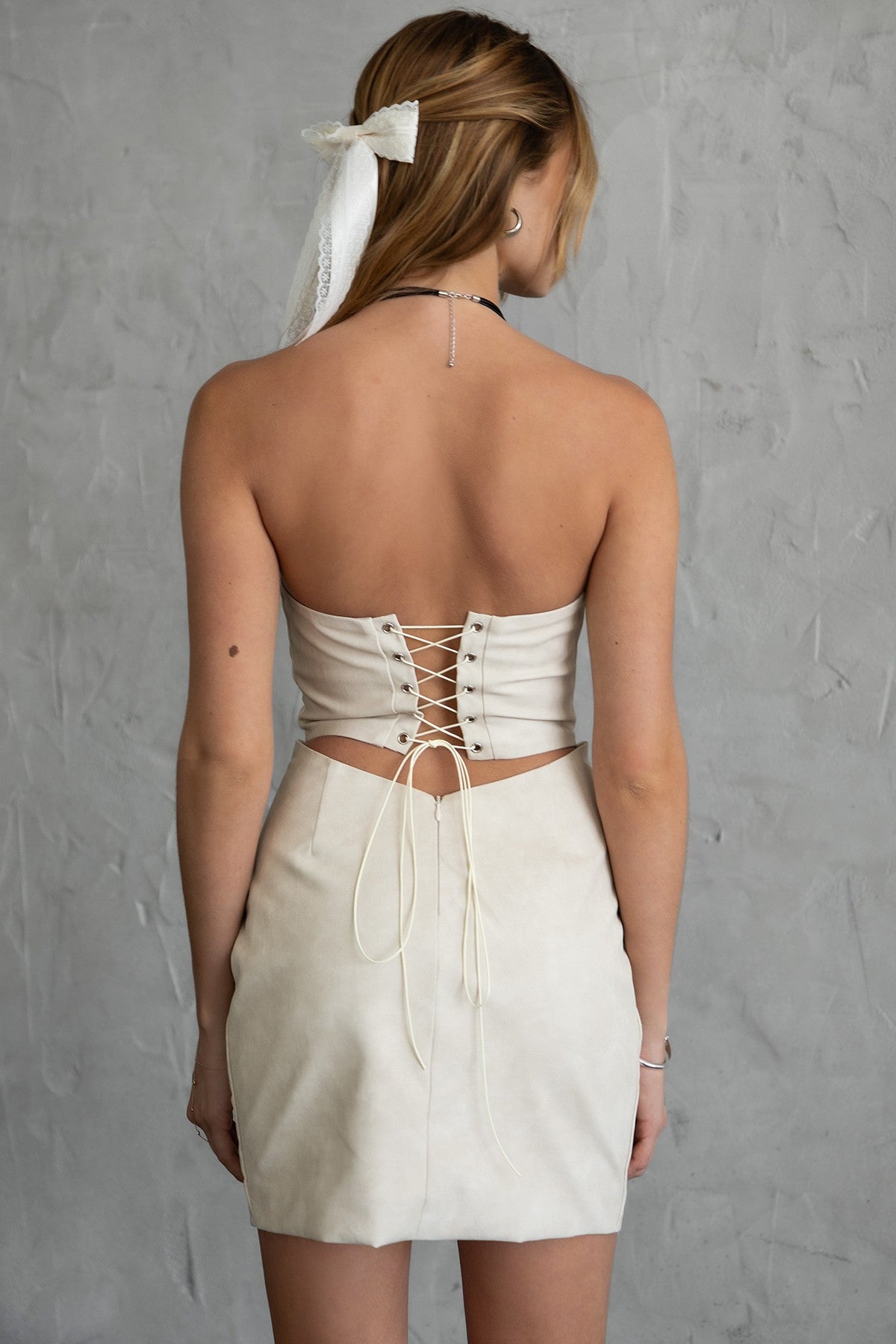 TIC TOC DA30447 ARIZONA Embroidered Western Mini Dress. A strapless PU vegan leather mini dress with a sweetheart neckline, open back lace-up tie, and Western-inspired embroidery.