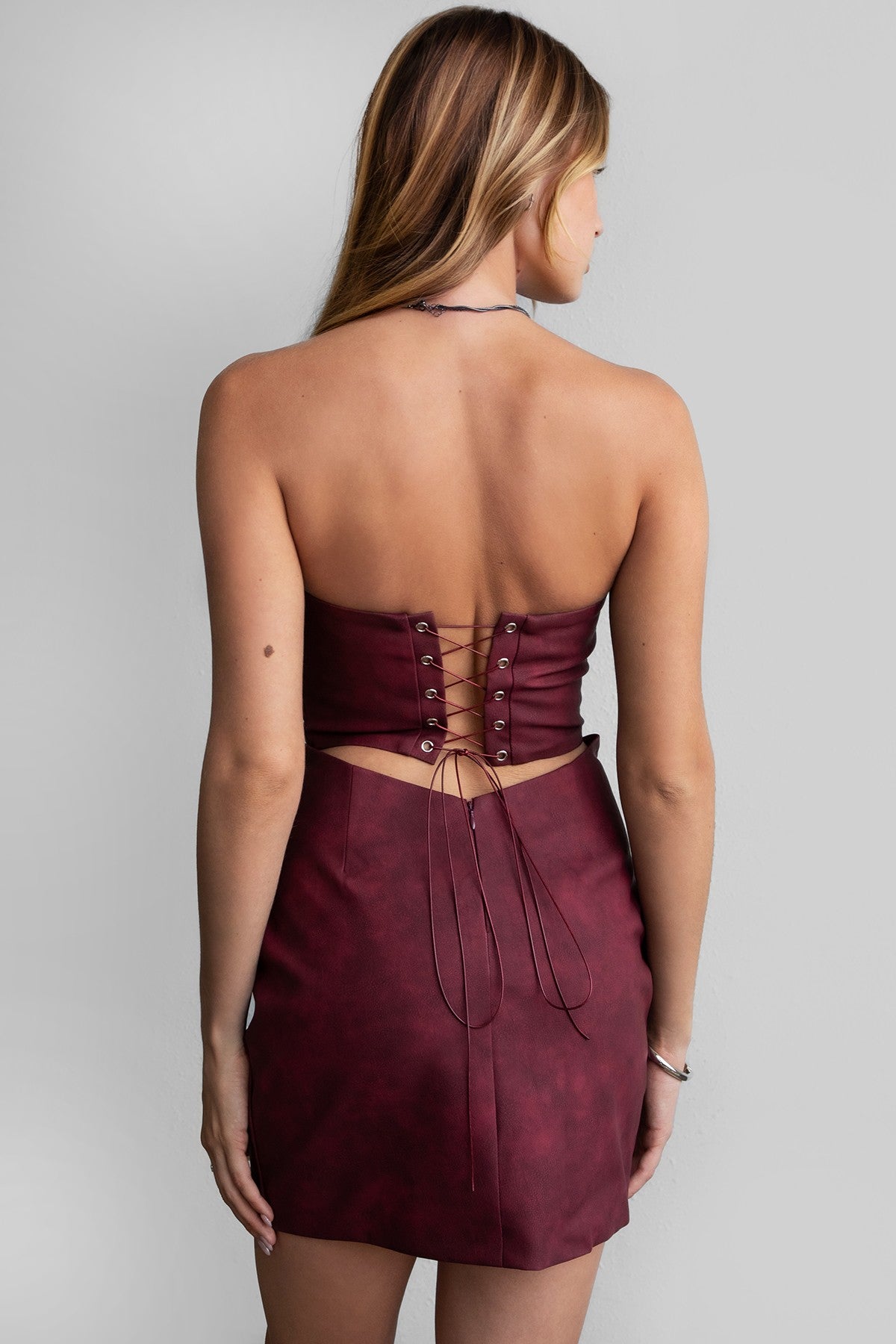 TIC TOC DA30447 ARIZONA Embroidered Western Mini Dress. A strapless PU vegan leather mini dress with a sweetheart neckline, open back lace-up tie, and Western-inspired embroidery.
