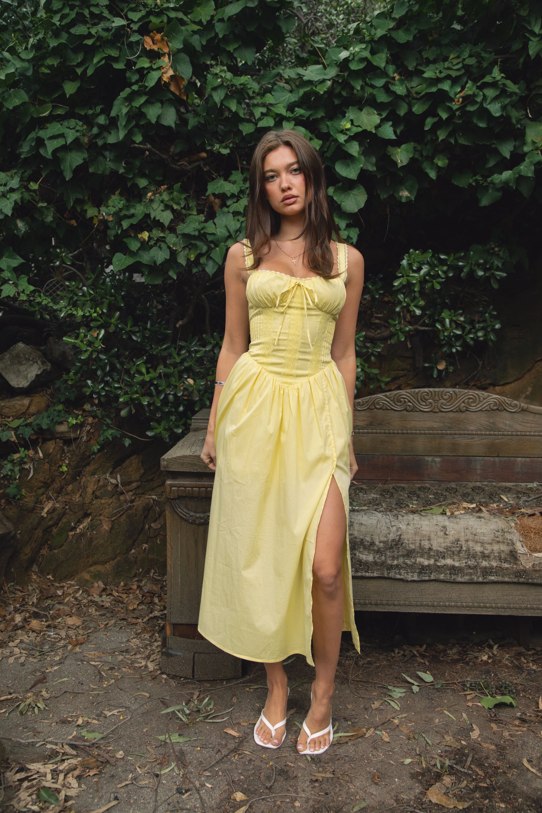 Woman wearing TIC TOC DA31086-LORETTA LORETTA stretch poplin maxi dress featuring adjustable lace shoulder straps, a cinched bust with bow detail, lace overlay corset-style bodice with vertical seaming, lace-up back and hidden side zipper, and a gathered A-line maxi skirt with a shaped waist and V-cut hip seam, styled for a romantic spring/summer occasion look.