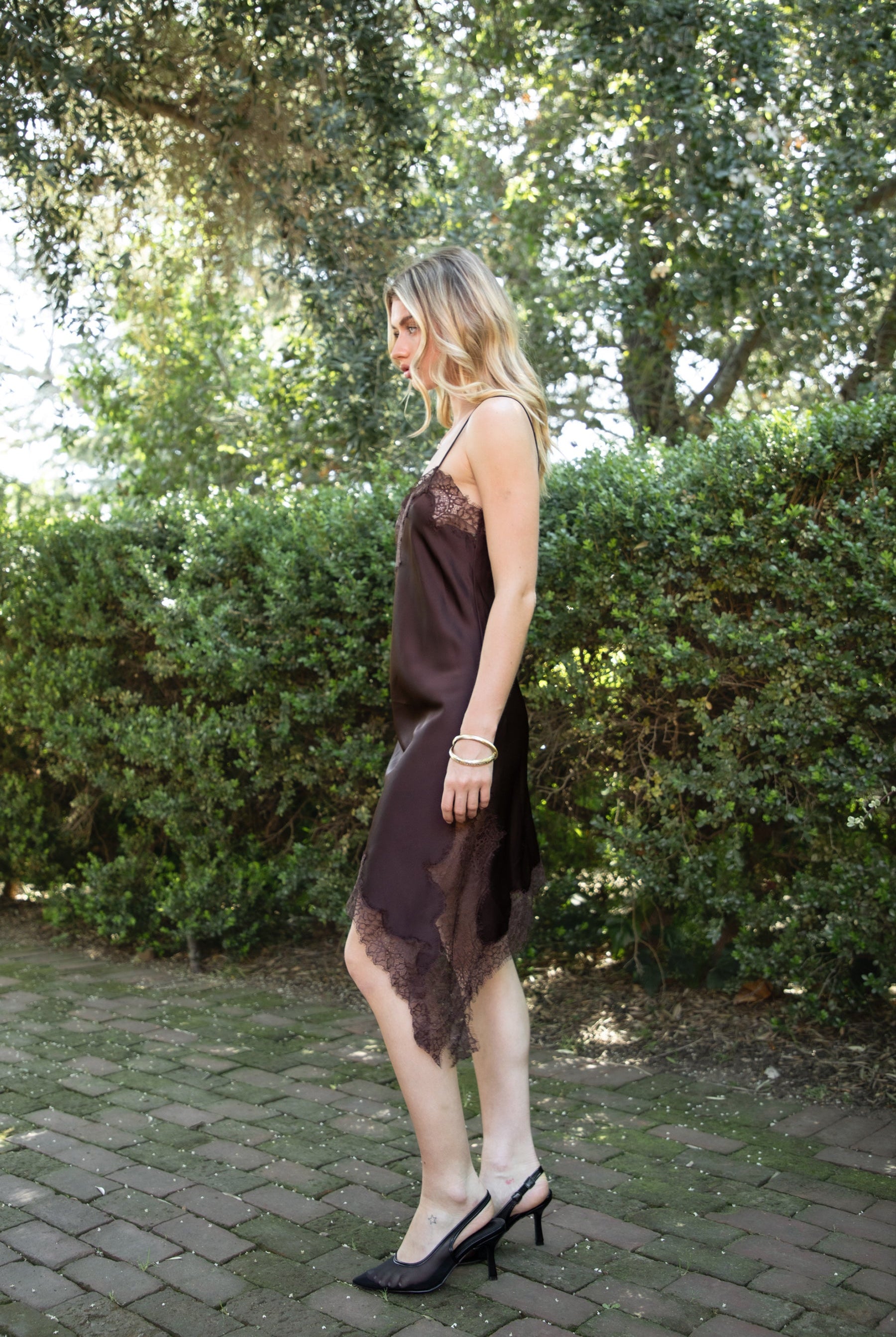 Woman wearing TIC TOC DA31971 LINORA satin lace contrast V-neck mini dress featuring a soft satin body, scalloped lace trim at the neckline, thin adjustable straps, asymmetrical lace-trim hem, and side slit detail for a sleek feminine night-out look.