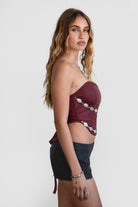 Model wearing LEIAH vegan leather micro shorts in black and brown, styled for a Western festival look