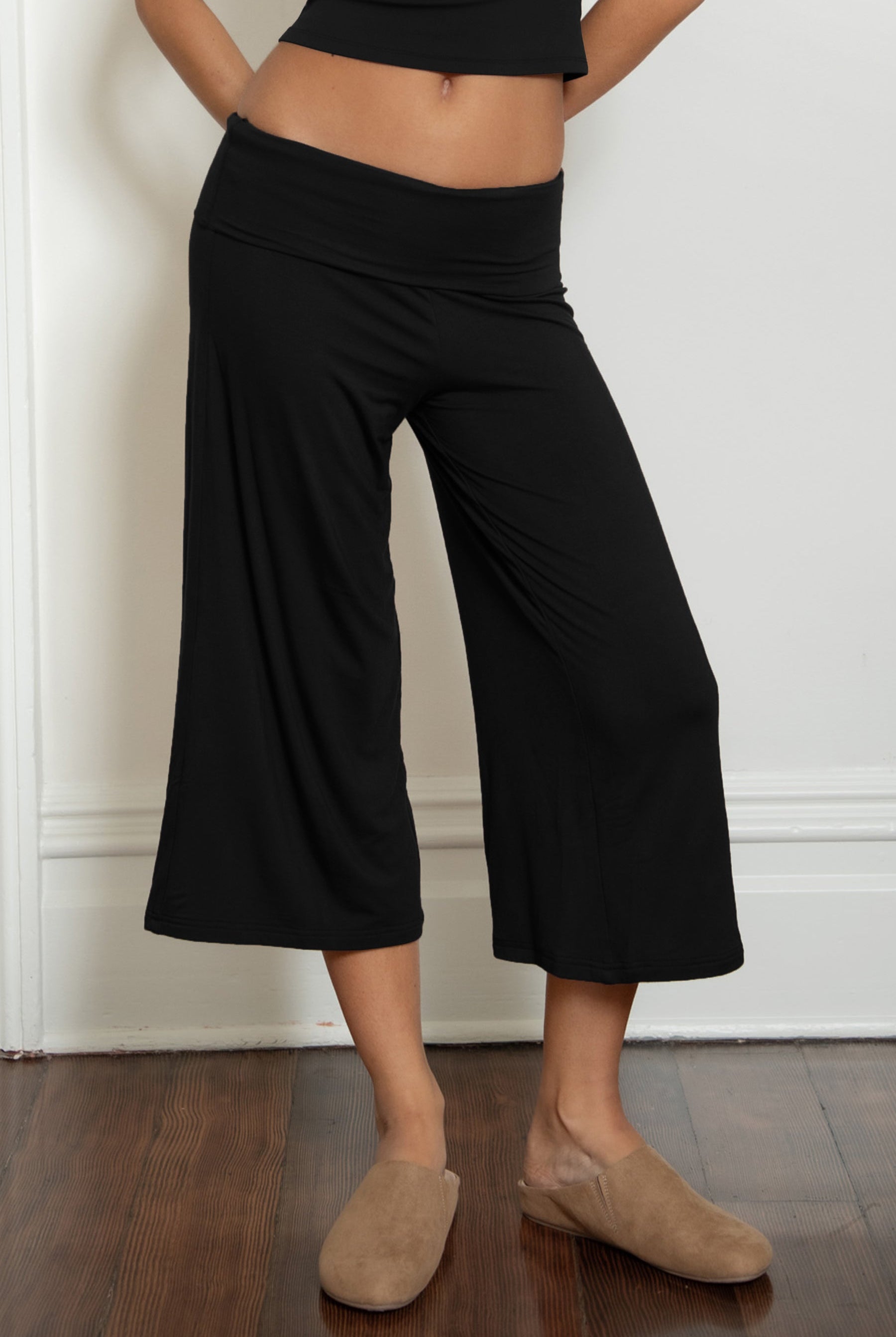 Woman wearing TIC TOC PH32000 SORA rayon spandex fold over low rise wide leg leggings featuring a soft lightweight jersey fabric, fold-over waistband, relaxed wide leg silhouette, and capri length, styled for a clean laid-back lounge and everyday look.