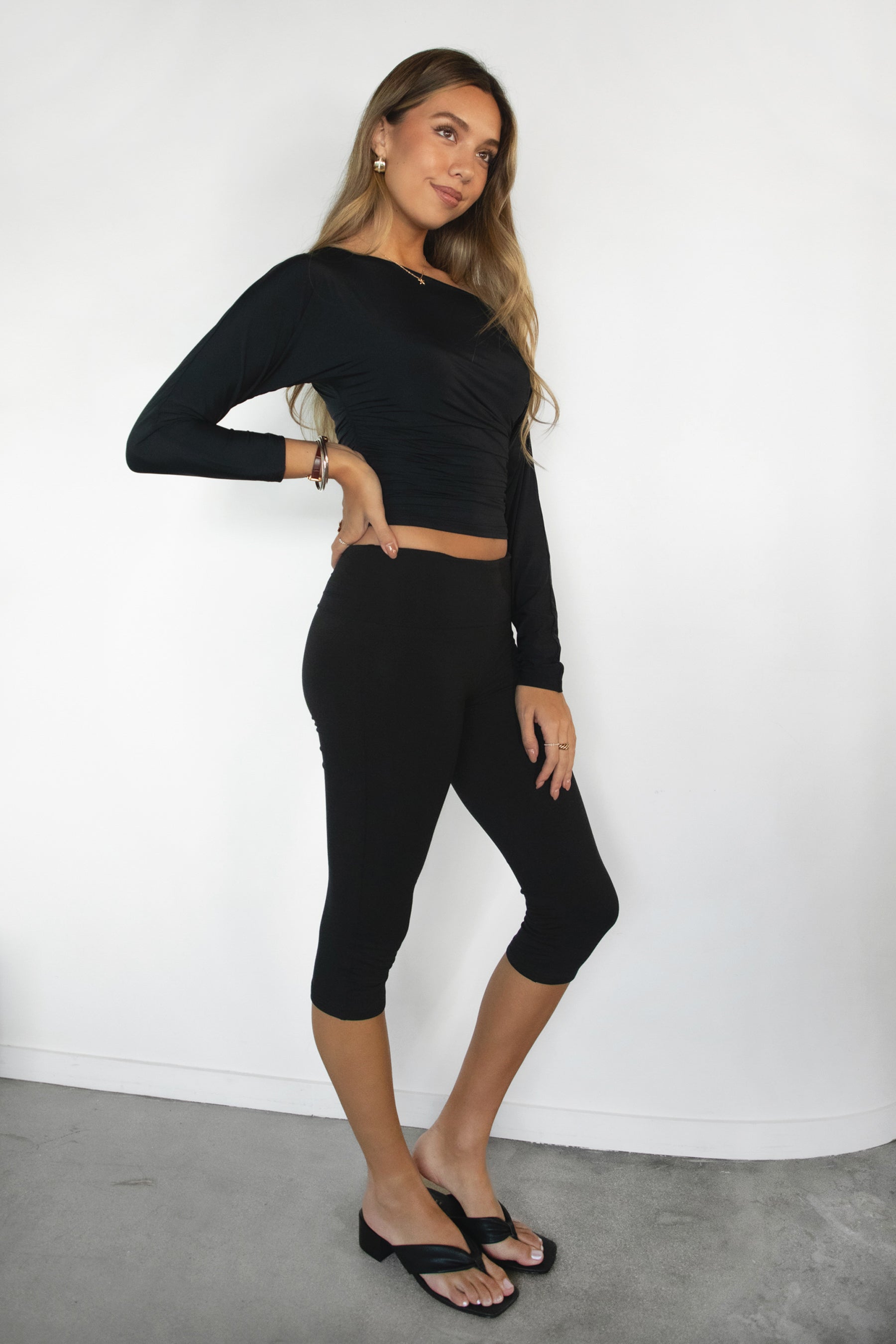 Woman wearing TIC TOC PH32001-SORA-SSP SORA capri leggings featuring a fold over waistband, mid rise fit, cropped capri length, slim body-hugging silhouette, and smooth stretch jersey fabric, styled with a fitted active top for an easy pilates-to-loungewear look.