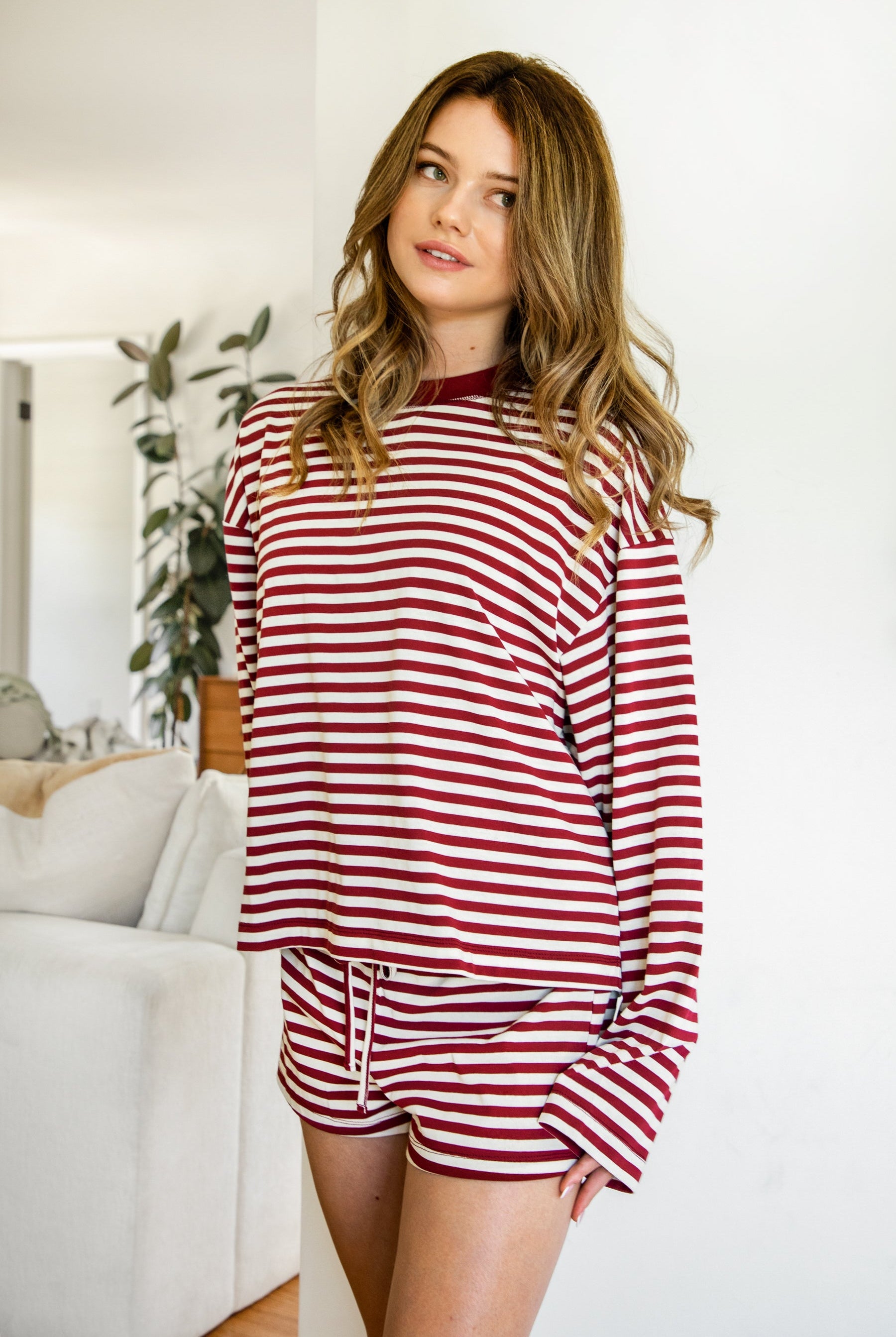 Woman wearing MARLOWE stripe mid waist drawstring stretch shorts featuring an allover stripe pattern, adjustable drawstring waistband, micro shorts length, relaxed easy fit silhouette, and soft stretch jersey fabric for cozy casual lounge styling.