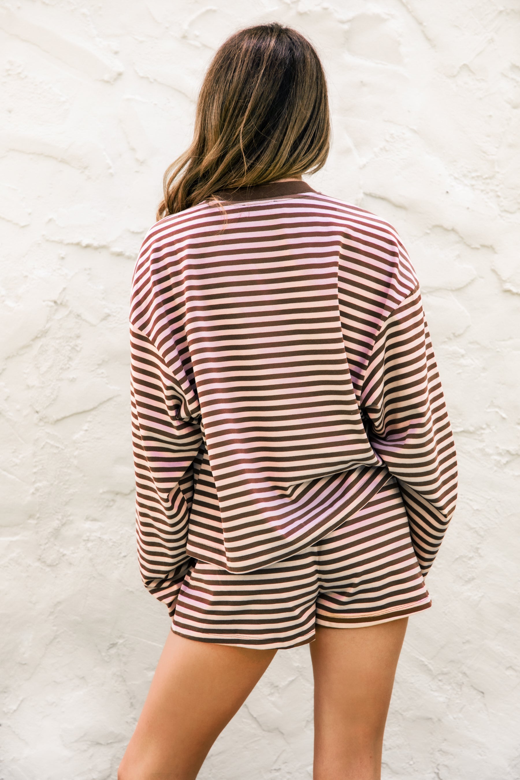 Woman wearing MARLOWE stripe mid waist drawstring stretch shorts featuring an allover stripe pattern, adjustable drawstring waistband, micro shorts length, relaxed easy fit silhouette, and soft stretch jersey fabric for cozy casual lounge styling.