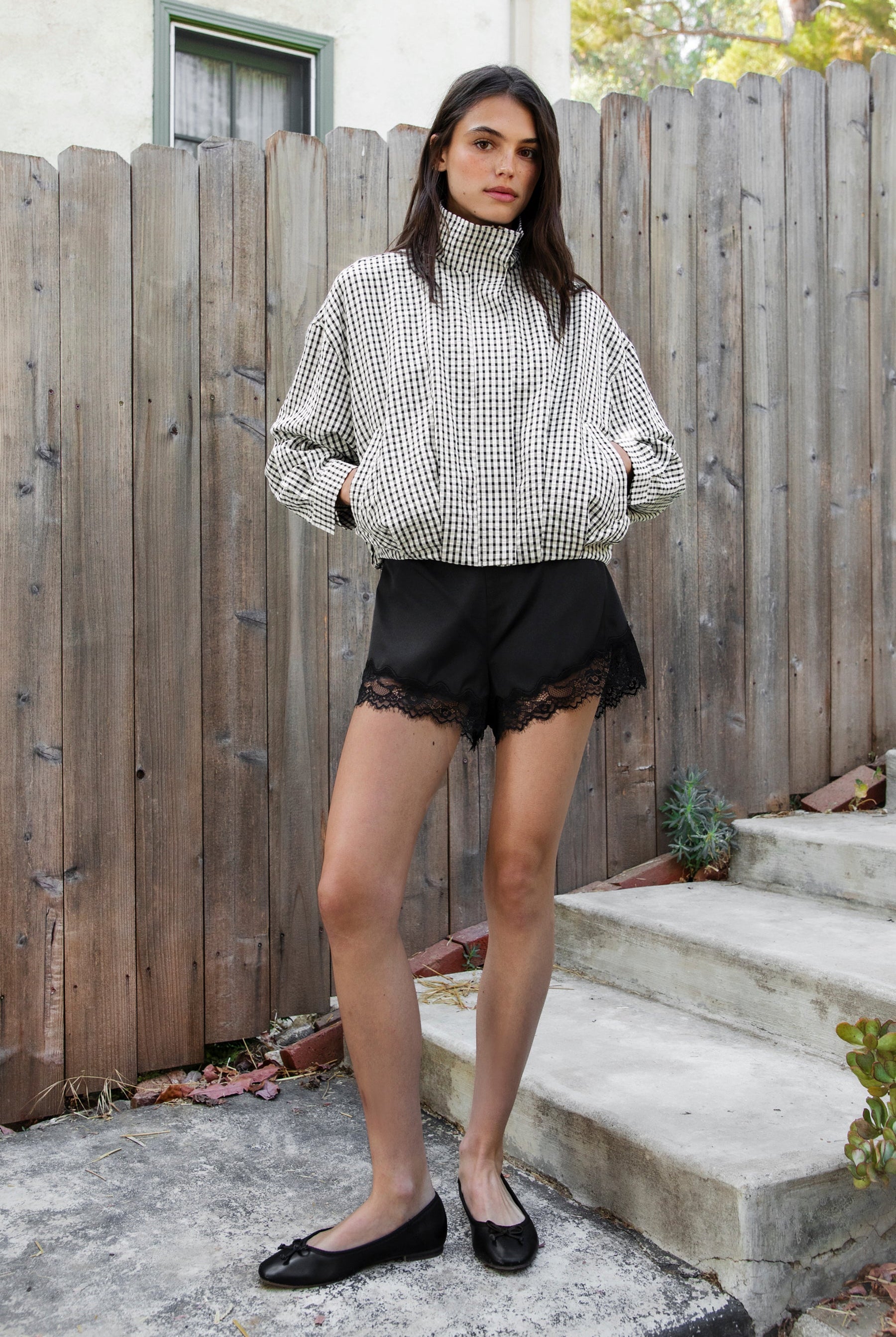 Woman wearing LUNETTE scalloped eyelash lace trim satin shorts featuring soft stretch satin fabric, high rise waist, clean tailored finish, delicate scalloped eyelash lace trim along the hem, hidden back zipper closure, and fully lined interior for added comfort and coverage.