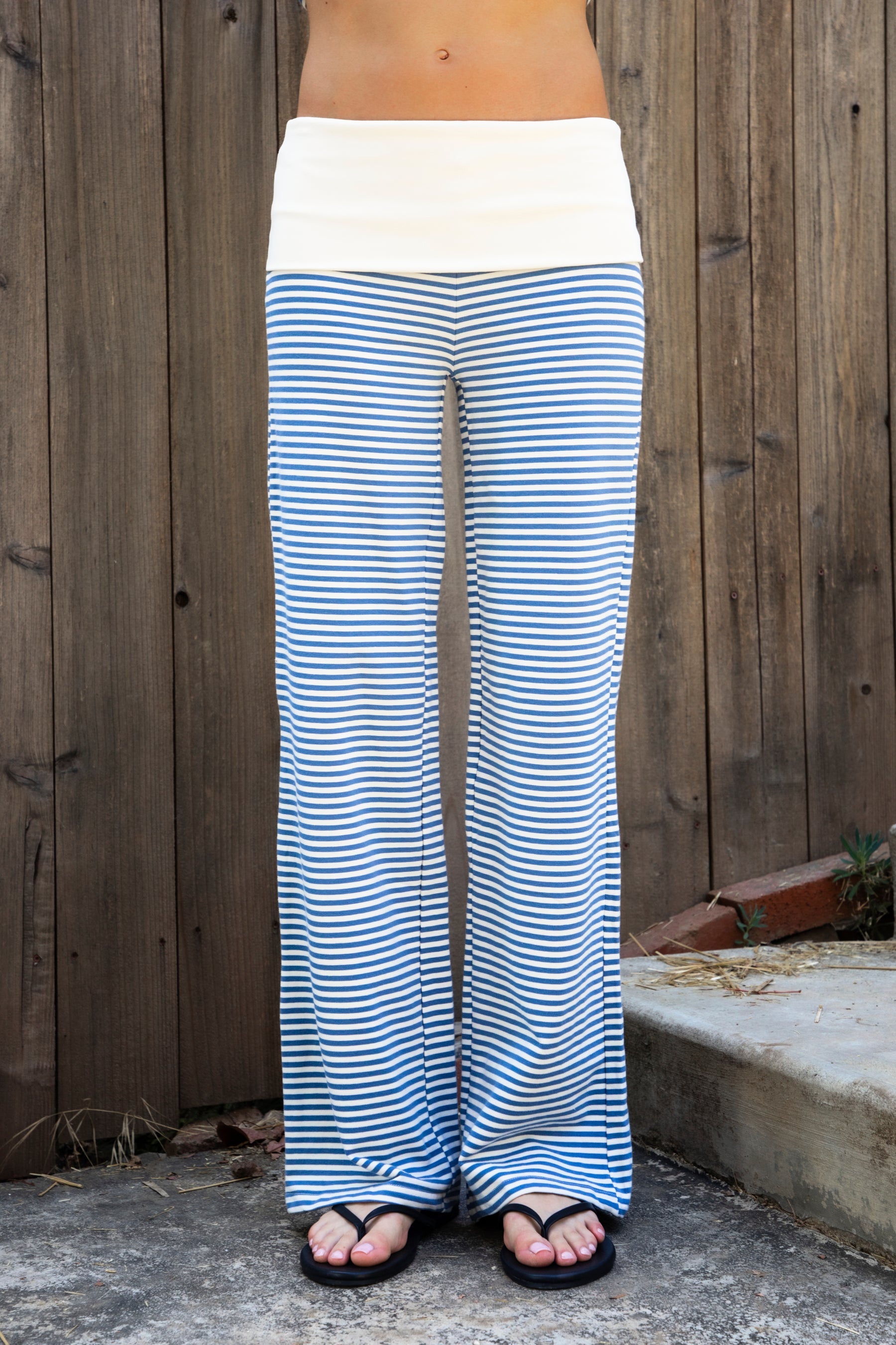Woman wearing BRISA French terry stripe foldover waist wide leg pants featuring soft stretch French terry fabric, contrast foldover waistband, flattering low rise look, relaxed wide leg silhouette, classic stripe pattern, and pull on design for easy lounge and travel styling.