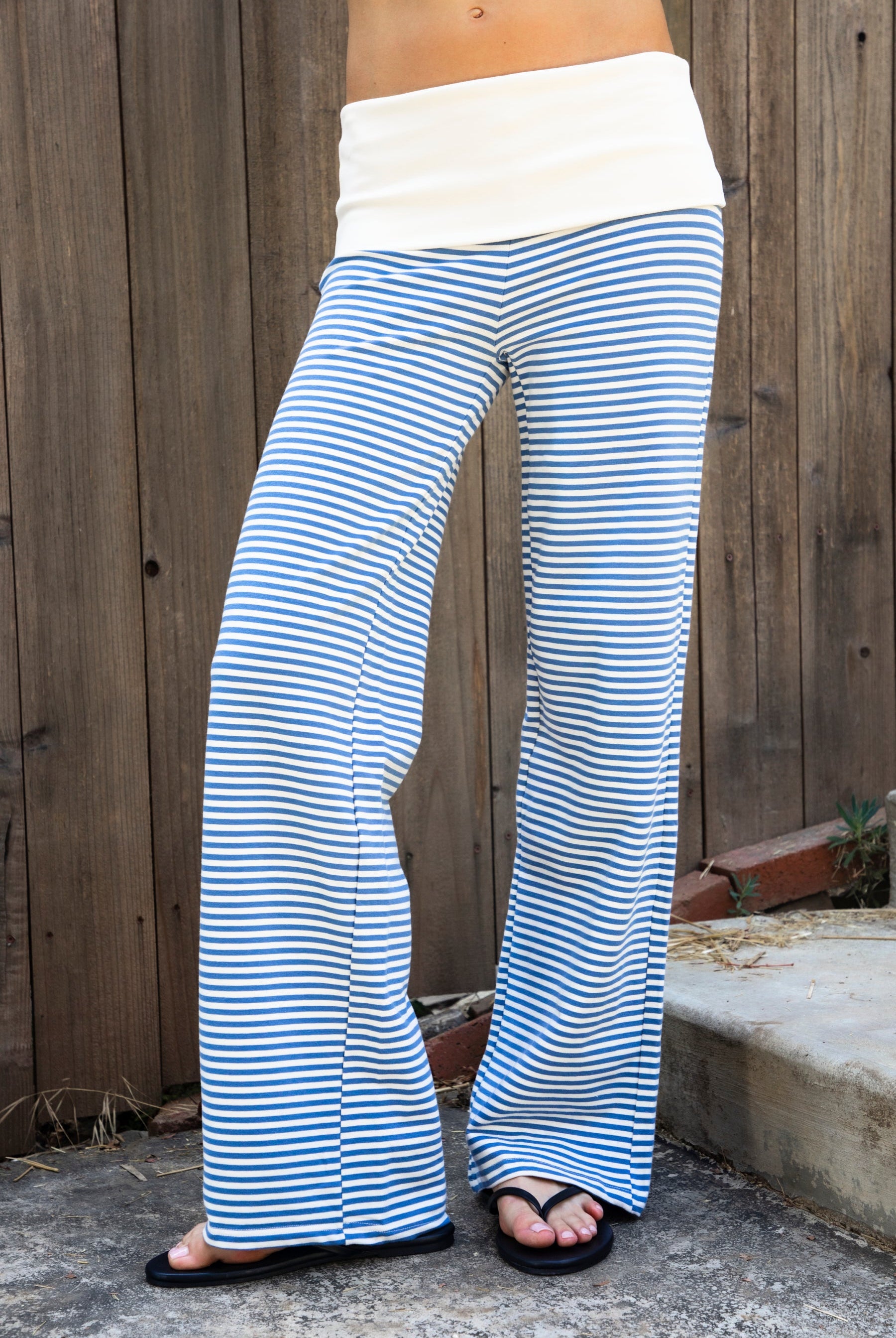 Woman wearing BRISA French terry stripe foldover waist wide leg pants featuring soft stretch French terry fabric, contrast foldover waistband, flattering low rise look, relaxed wide leg silhouette, classic stripe pattern, and pull on design for easy lounge and travel styling.