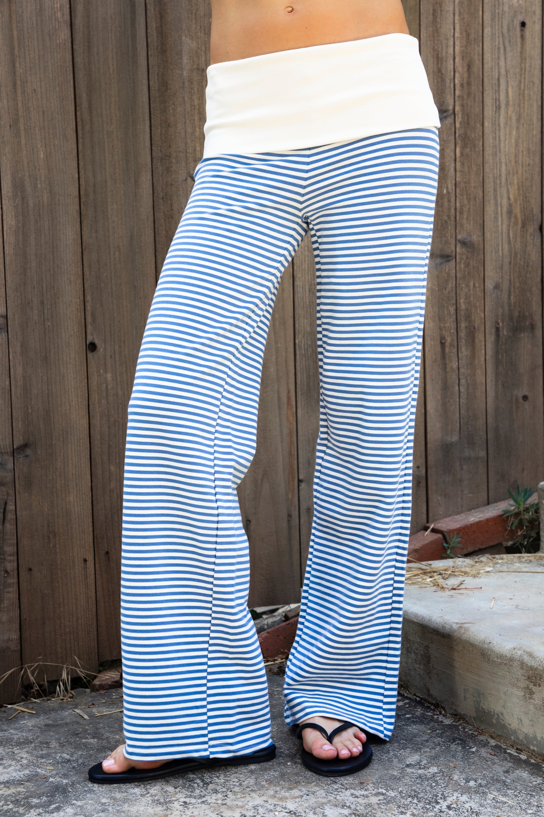 Woman wearing BRISA French terry stripe foldover waist wide leg pants featuring soft stretch French terry fabric, contrast foldover waistband, flattering low rise look, relaxed wide leg silhouette, classic stripe pattern, and pull on design for easy lounge and travel styling.