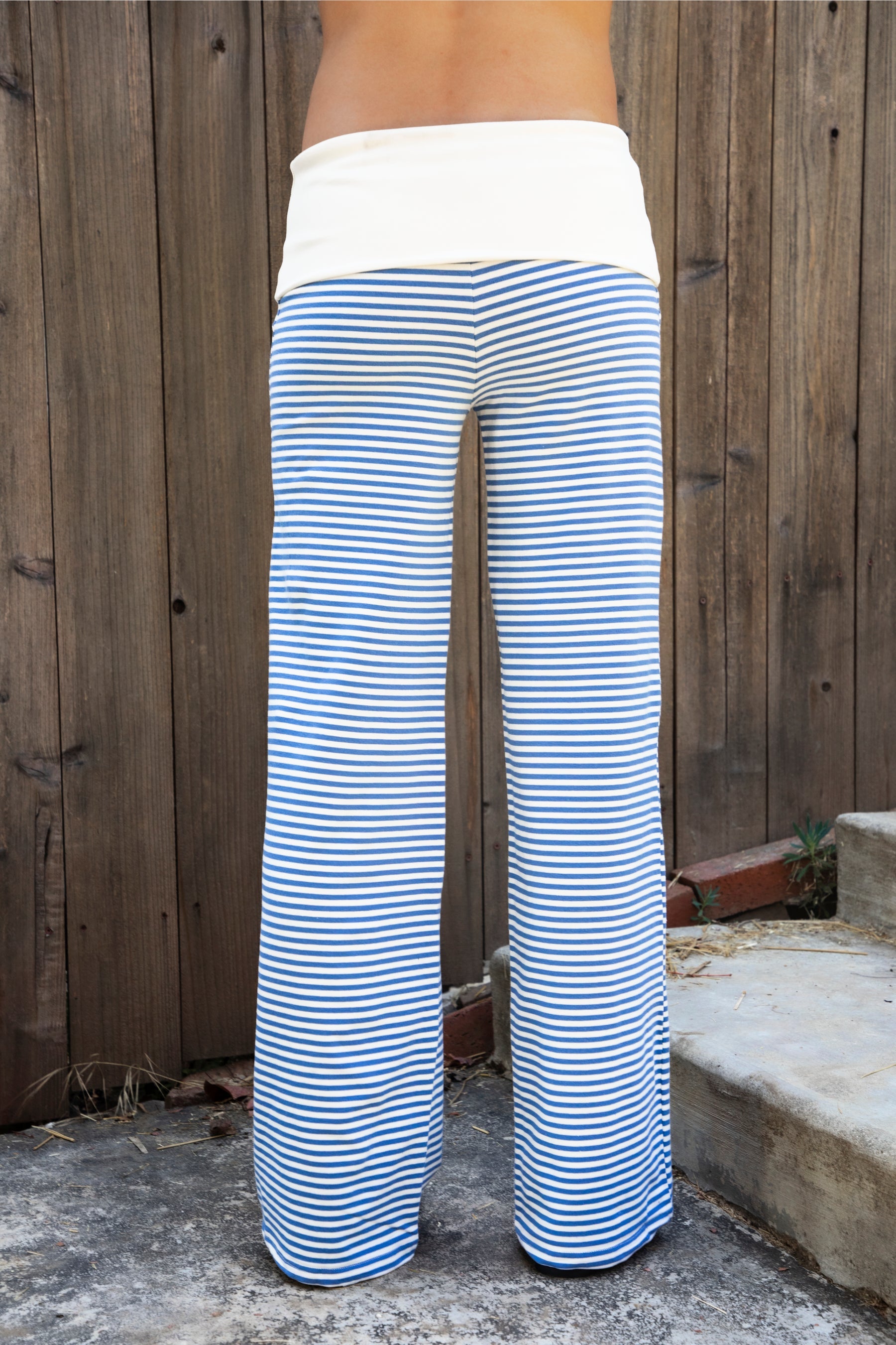 Woman wearing BRISA French terry stripe foldover waist wide leg pants featuring soft stretch French terry fabric, contrast foldover waistband, flattering low rise look, relaxed wide leg silhouette, classic stripe pattern, and pull on design for easy lounge and travel styling.