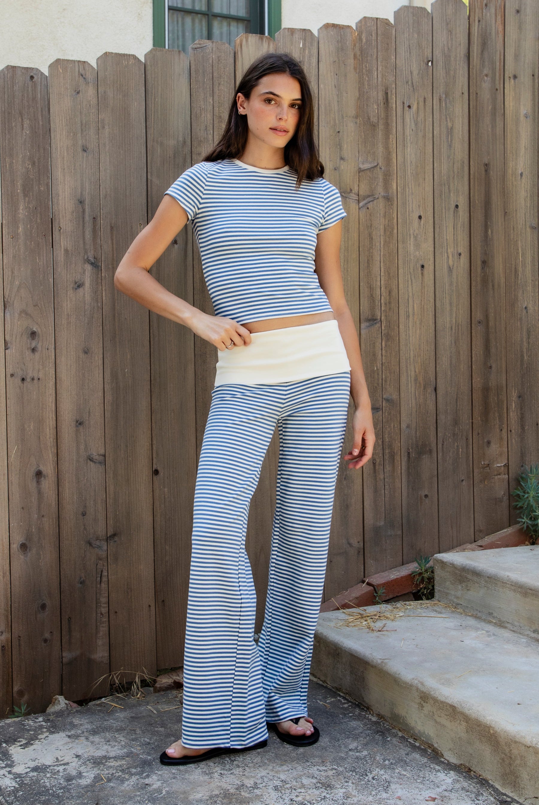 Woman wearing BRISA French terry stripe foldover waist wide leg pants featuring soft stretch French terry fabric, contrast foldover waistband, flattering low rise look, relaxed wide leg silhouette, classic stripe pattern, and pull on design for easy lounge and travel styling.