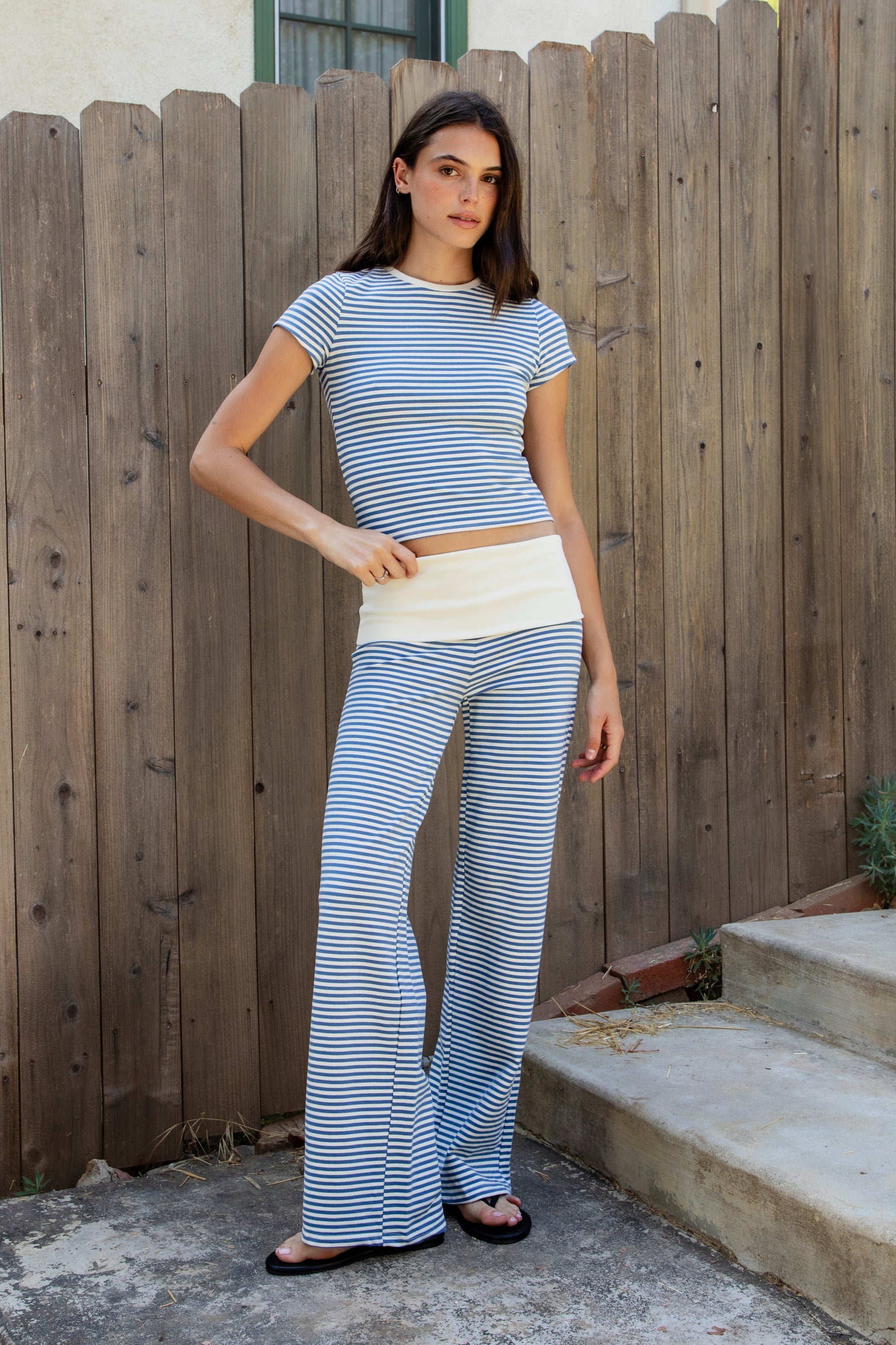 Woman wearing BRISA French terry stripe foldover waist wide leg pants featuring soft stretch French terry fabric, contrast foldover waistband, flattering low rise look, relaxed wide leg silhouette, classic stripe pattern, and pull on design for easy lounge and travel styling.