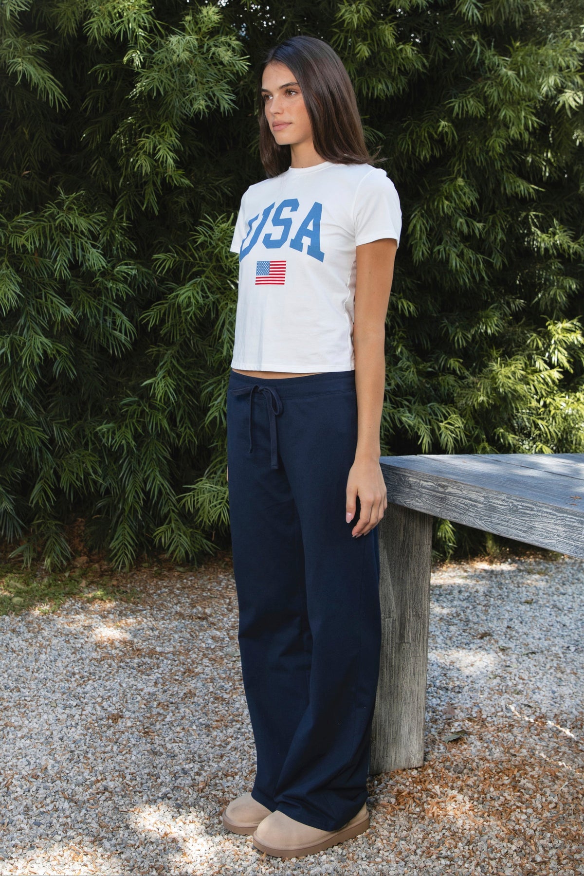 Woman wearing NAVYN waist band cotton wide leg pants featuring soft 100 percent cotton fabric, low rise waistline, relaxed fit, elastic waistband with adjustable drawstring tie, relaxed silhouette through the hips and thighs, wide leg design, full length cut, and straight hem for easy everyday styling.