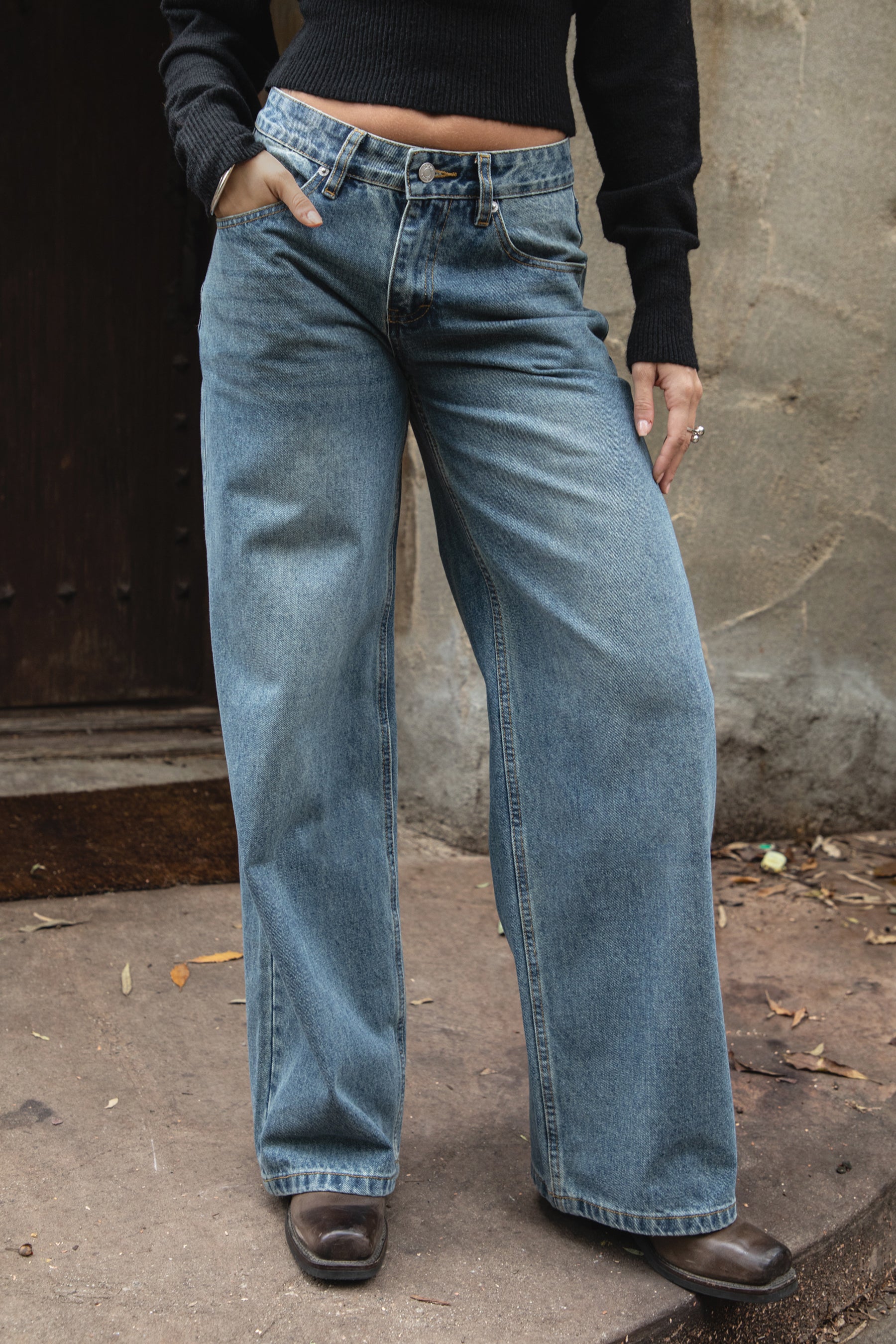 Woman wearing TIC TOC PJ31550-WINSLEY WINSLEY low rise straight leg denim jeans in a vintage blue wash with light fading, featuring a long straight wide leg silhouette, classic 5-pocket styling, belt loops, and a zipper fly button closure, styled casually with a fitted top for an everyday denim look.