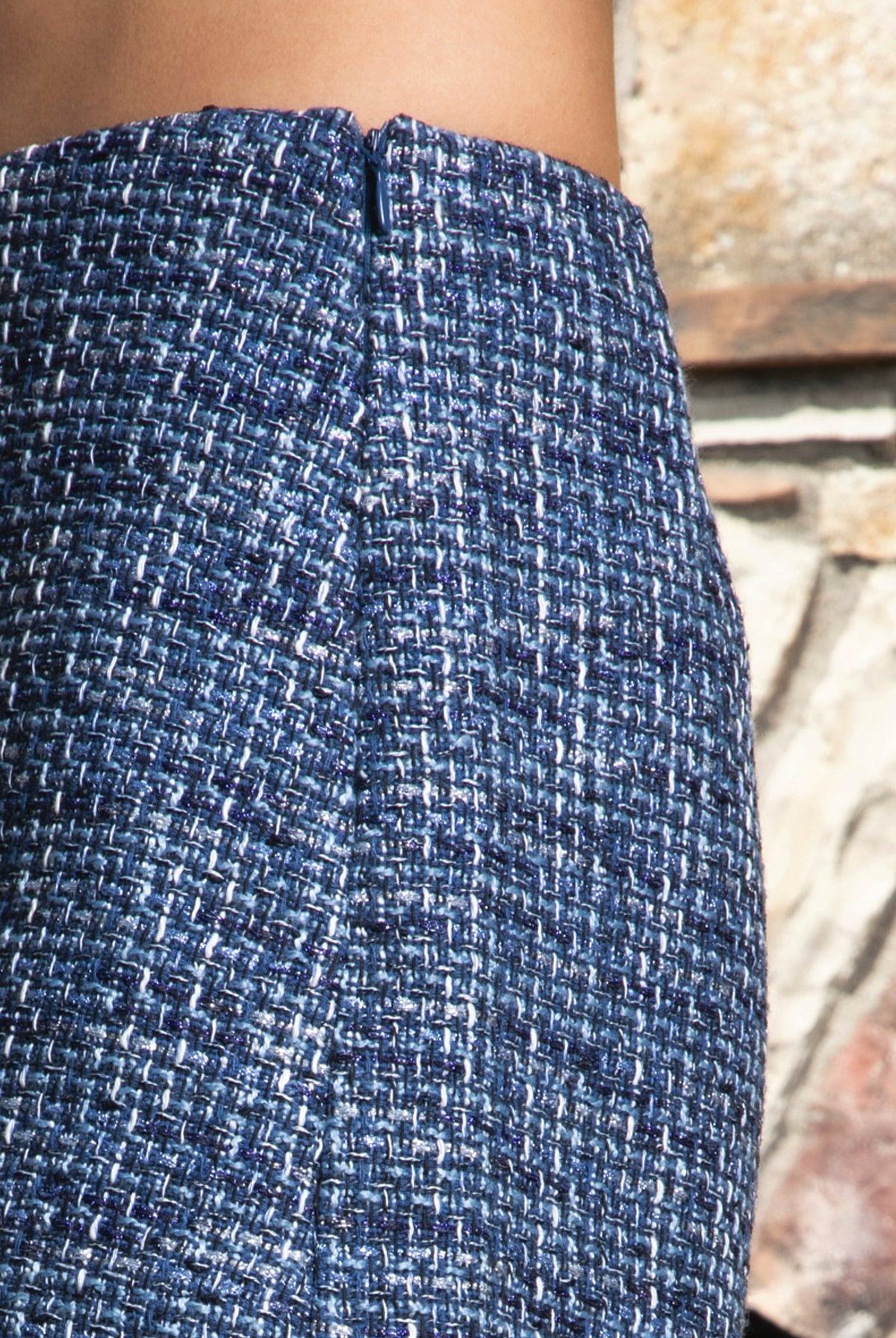 Woman wearing COCO navy blue lurex tweed skort featuring shimmering textured tweed fabric, subtle metallic lurex detail, mini length, skirt inspired front with hidden shorts comfort, clean fitted waist, side zipper closure, and fully lined construction for going out and holiday styling.