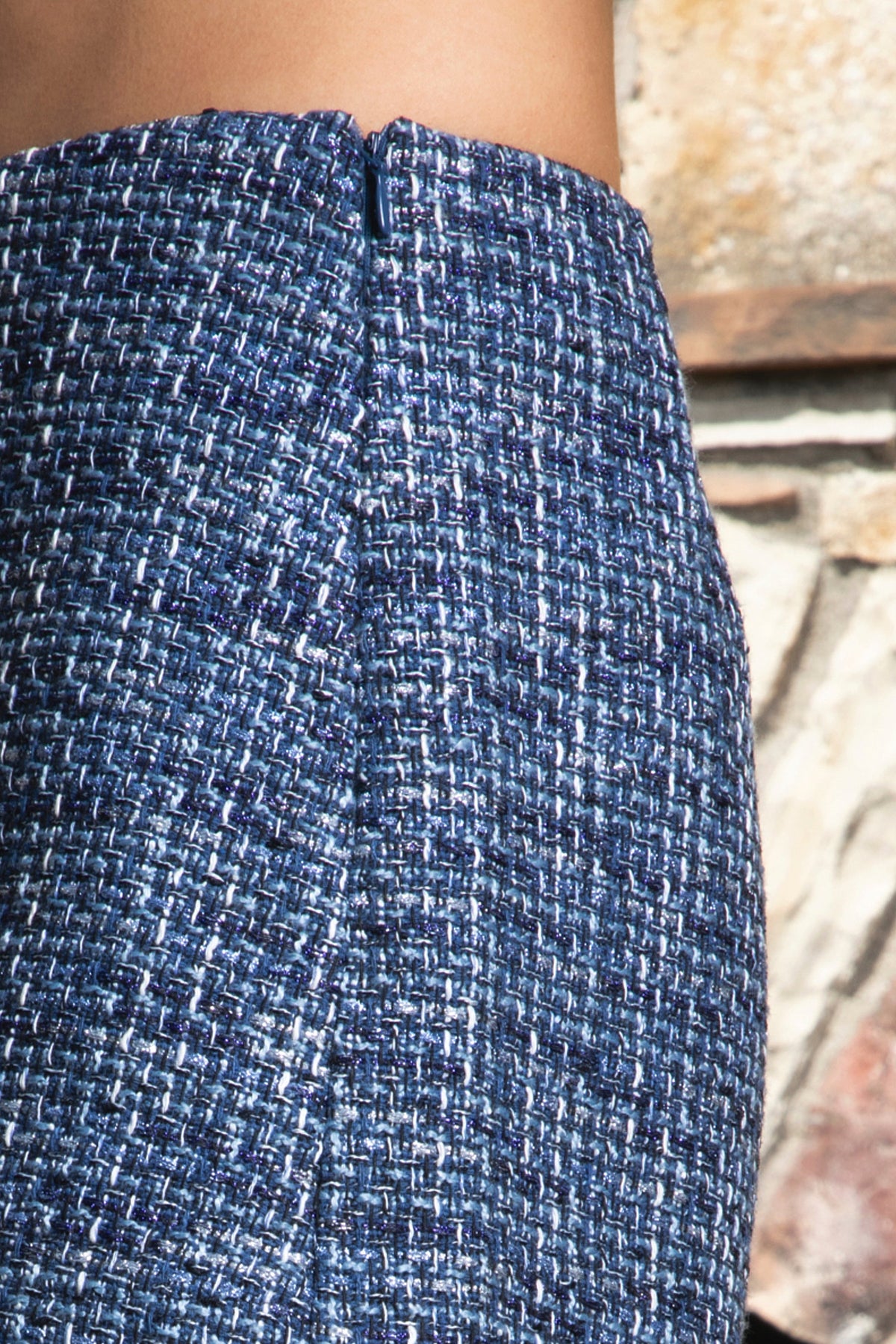 Woman wearing COCO navy blue lurex tweed skort featuring shimmering textured tweed fabric, subtle metallic lurex detail, mini length, skirt inspired front with hidden shorts comfort, clean fitted waist, side zipper closure, and fully lined construction for going out and holiday styling.