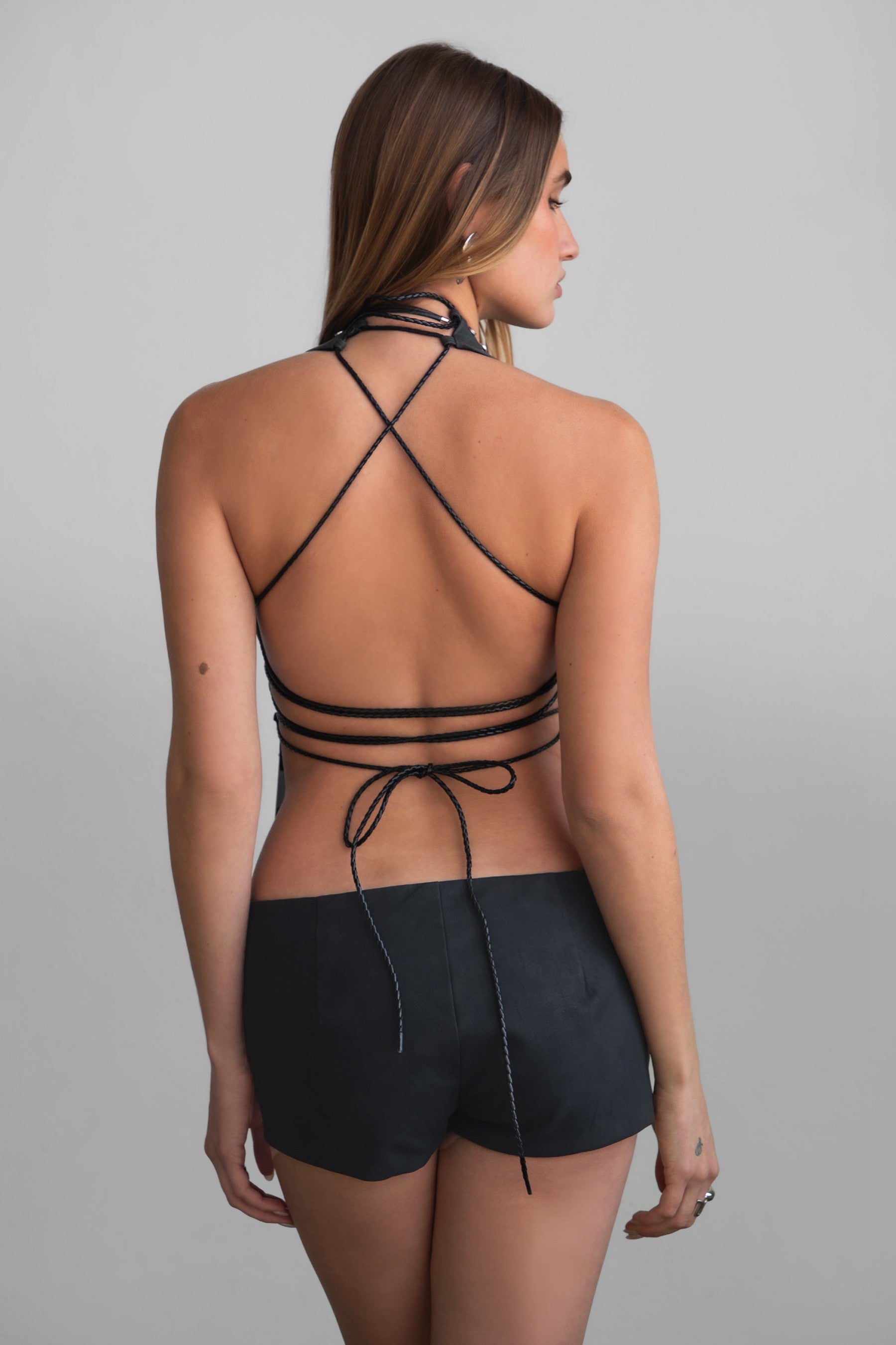 TIC TOC TA31106 LYLA Distressed Leather Studded Halter Top. Open torso lace-up design with studded details, perfect for festivals and Western-inspired outfits.