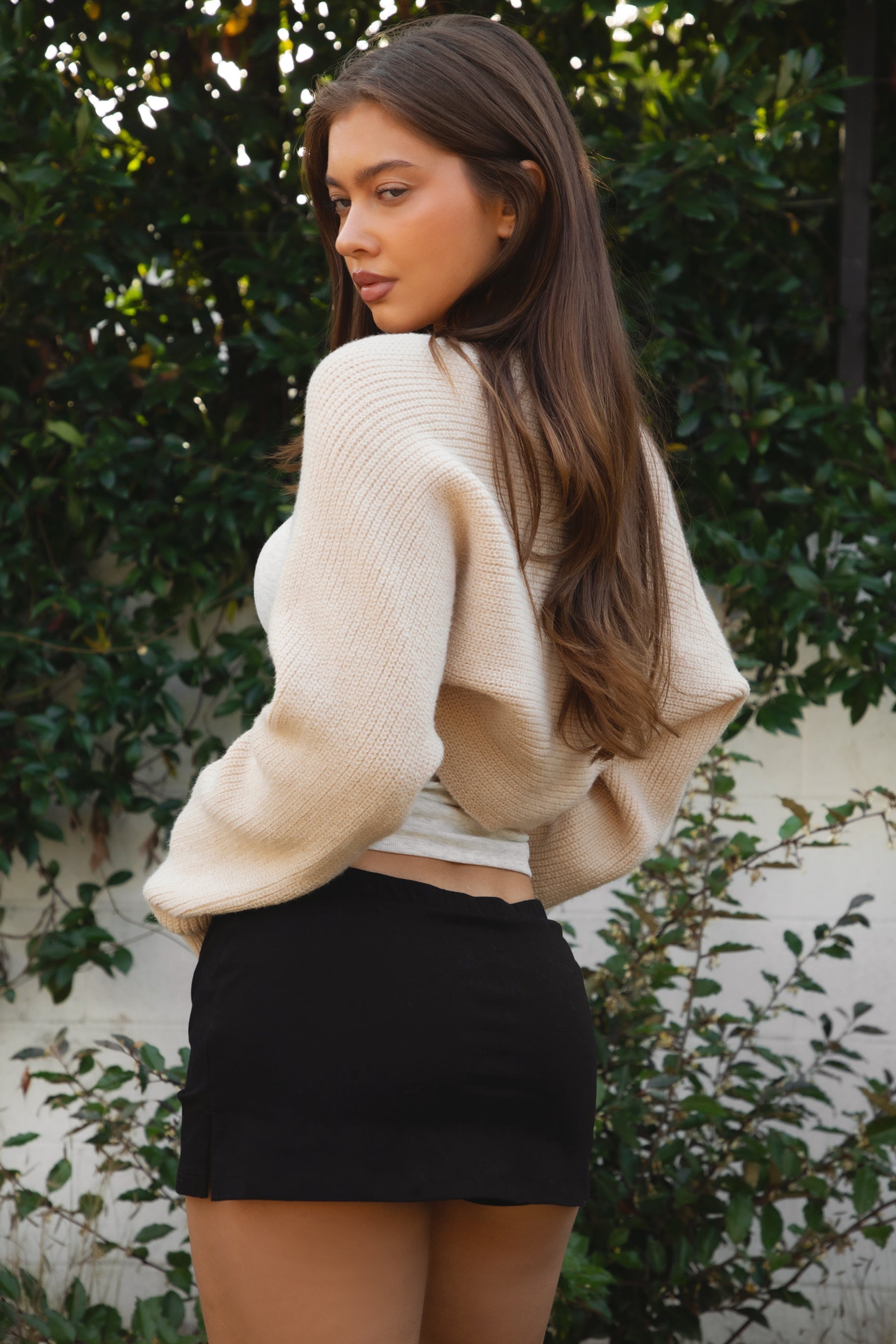 Woman wearing TIC TOC TC28065-FLUFF FLUFF shrug style crop cardigan bolero featuring an open front construction, easy semi loose fit, ultra cropped hem at the waist, and long semi loose sleeves finished with ribbed fitted cuffs, styled layered over a fitted tank and high-rise bottoms for a light, versatile everyday look.