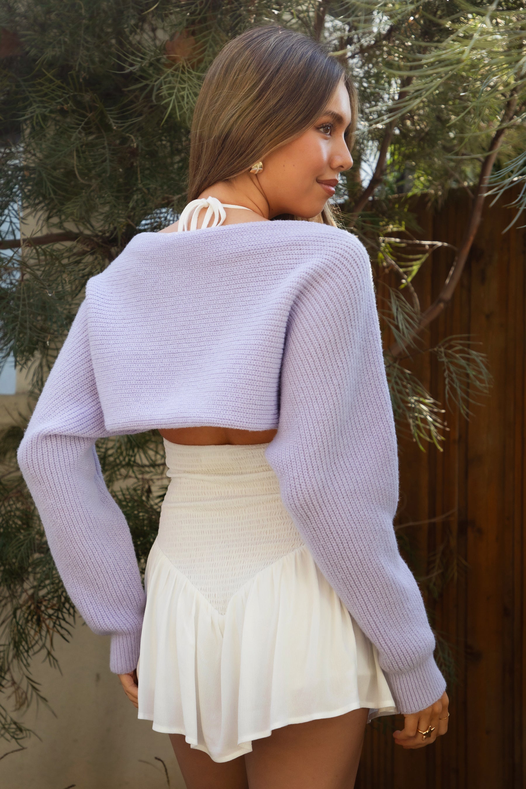 Woman wearing TIC TOC TC28065-FLUFF FLUFF shrug style crop cardigan bolero featuring an open front construction, easy semi loose fit, ultra cropped hem at the waist, and long semi loose sleeves finished with ribbed fitted cuffs, styled layered over a fitted tank and high-rise bottoms for a light, versatile everyday look.