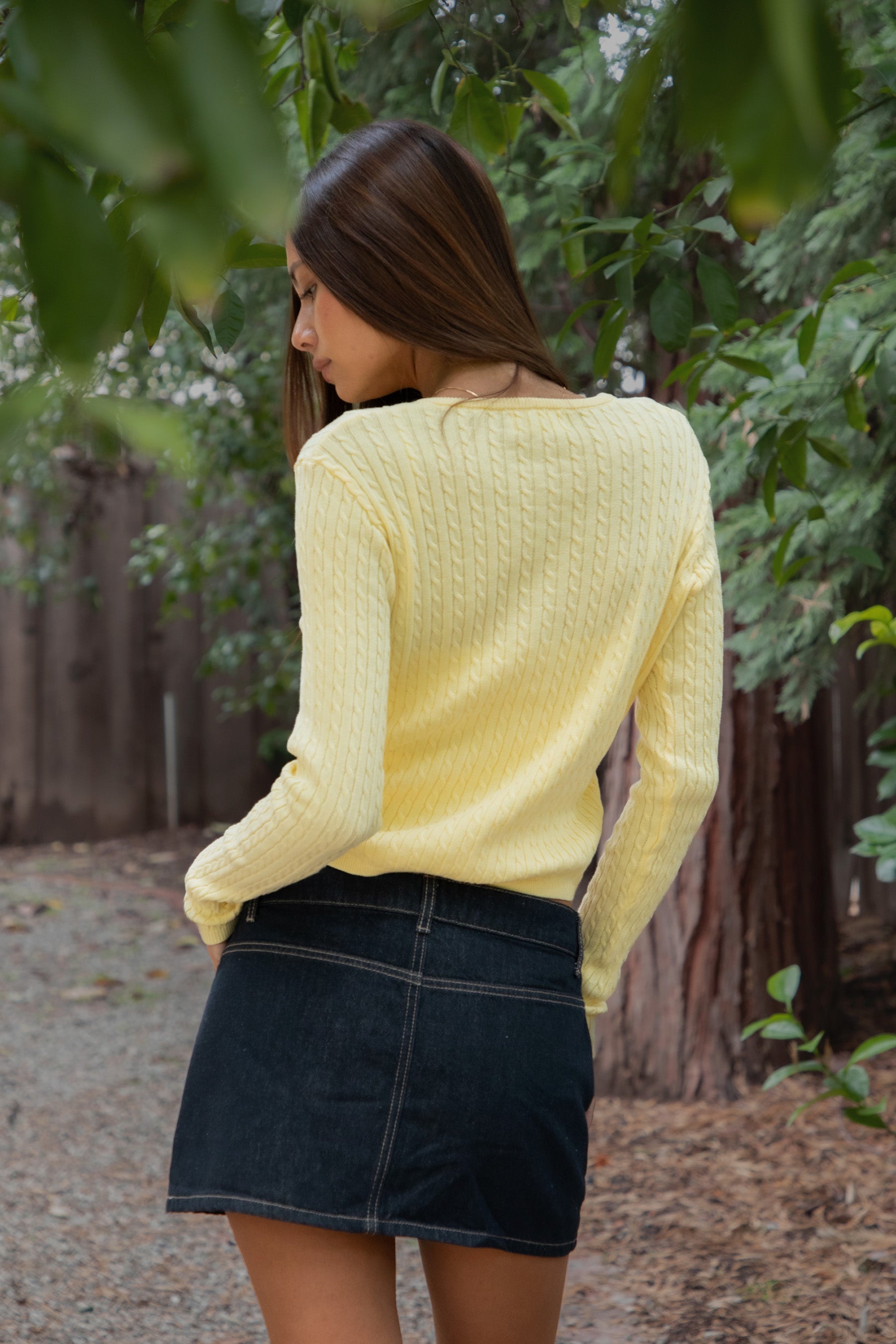 Woman wearing TIC TOC TC32069 KRISTY cable knit basic long sleeve cardigan top featuring a soft lightweight cotton cable knit texture, round neckline, full front button closure, slim fit silhouette, and semi-cropped length for a polished preppy everyday look.