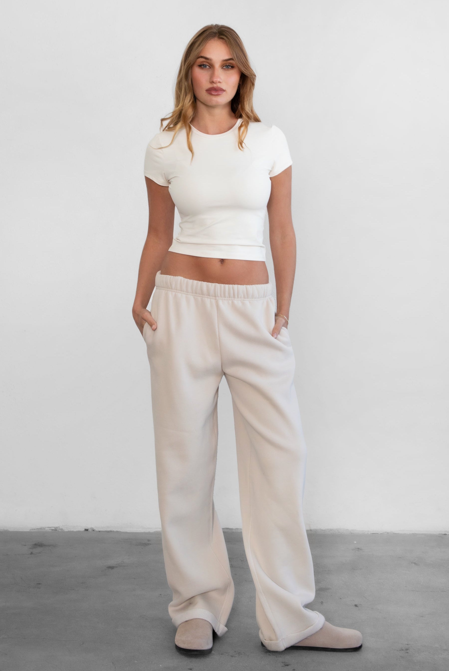 Woman wearing TIC TOC TH31439BA-ARIET ARIET brushed poly short sleeve top featuring a high round neckline, short cap sleeves, smooth bodyhugging stretch fabric, and a clean minimal silhouette, styled with matching fleece joggers as a coordinated lounge set.