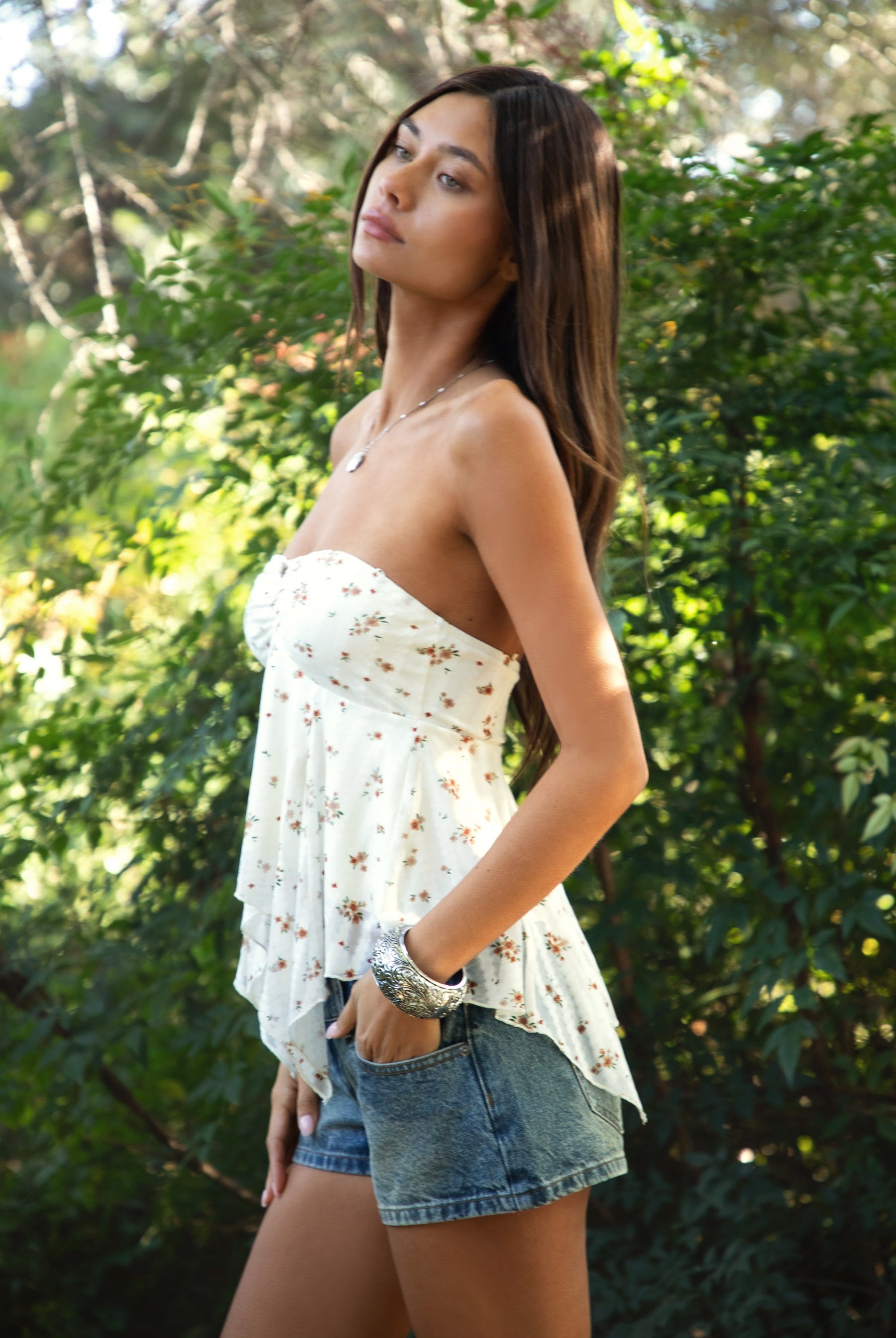 Woman wearing TIC TOC TH31655 APRICOT floral stripe sheer babydoll tank top featuring soft stretch lace fabric with delicate floral and stripe print, a ruched strapless bust, layered sheer design with light milk lining, and a ruffled handkerchief hem for a romantic western-inspired summer look.