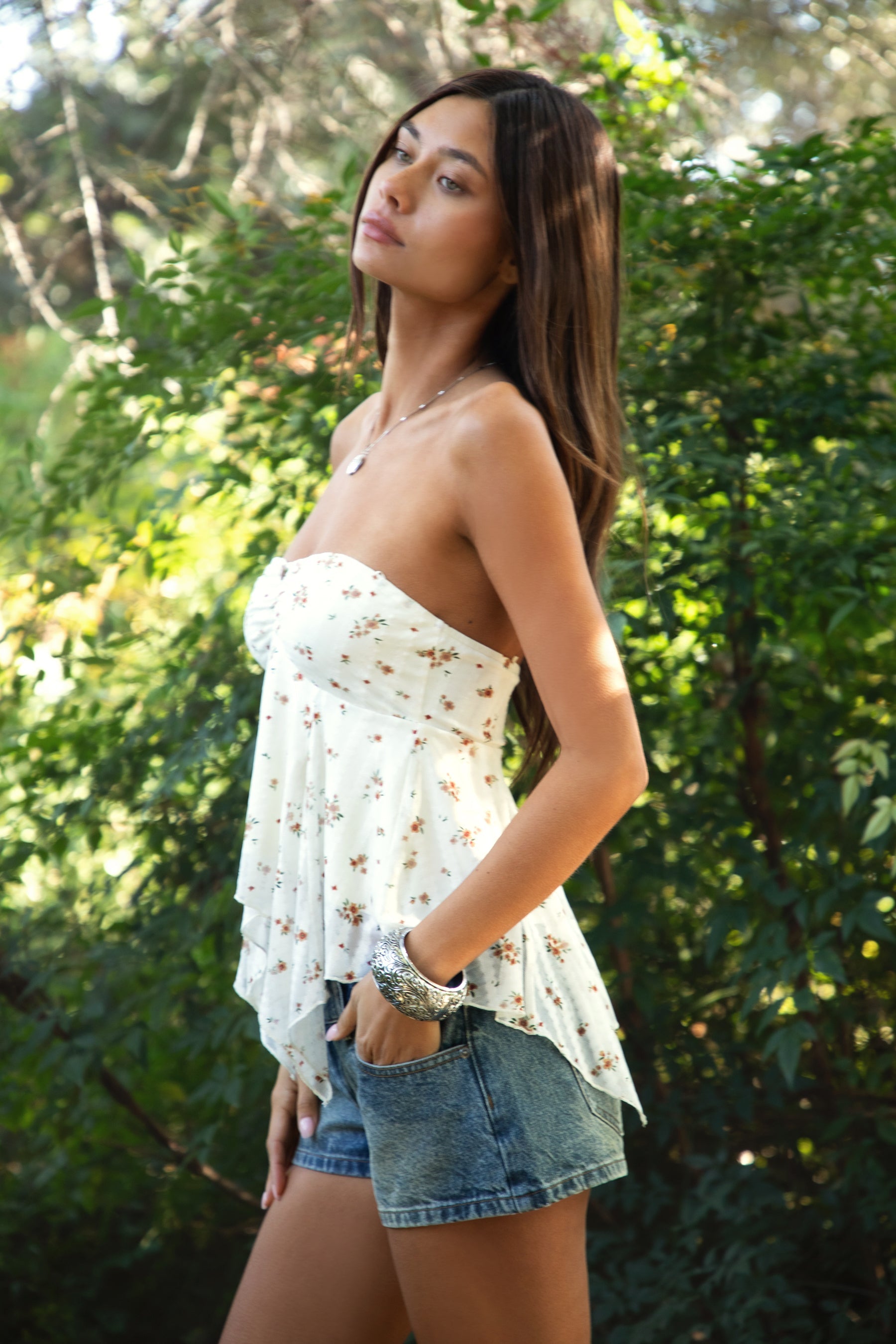 Woman wearing TIC TOC TH31655 APRICOT floral stripe sheer babydoll tank top featuring soft stretch lace fabric with delicate floral and stripe print, a ruched strapless bust, layered sheer design with light milk lining, and a ruffled handkerchief hem for a romantic western-inspired summer look.