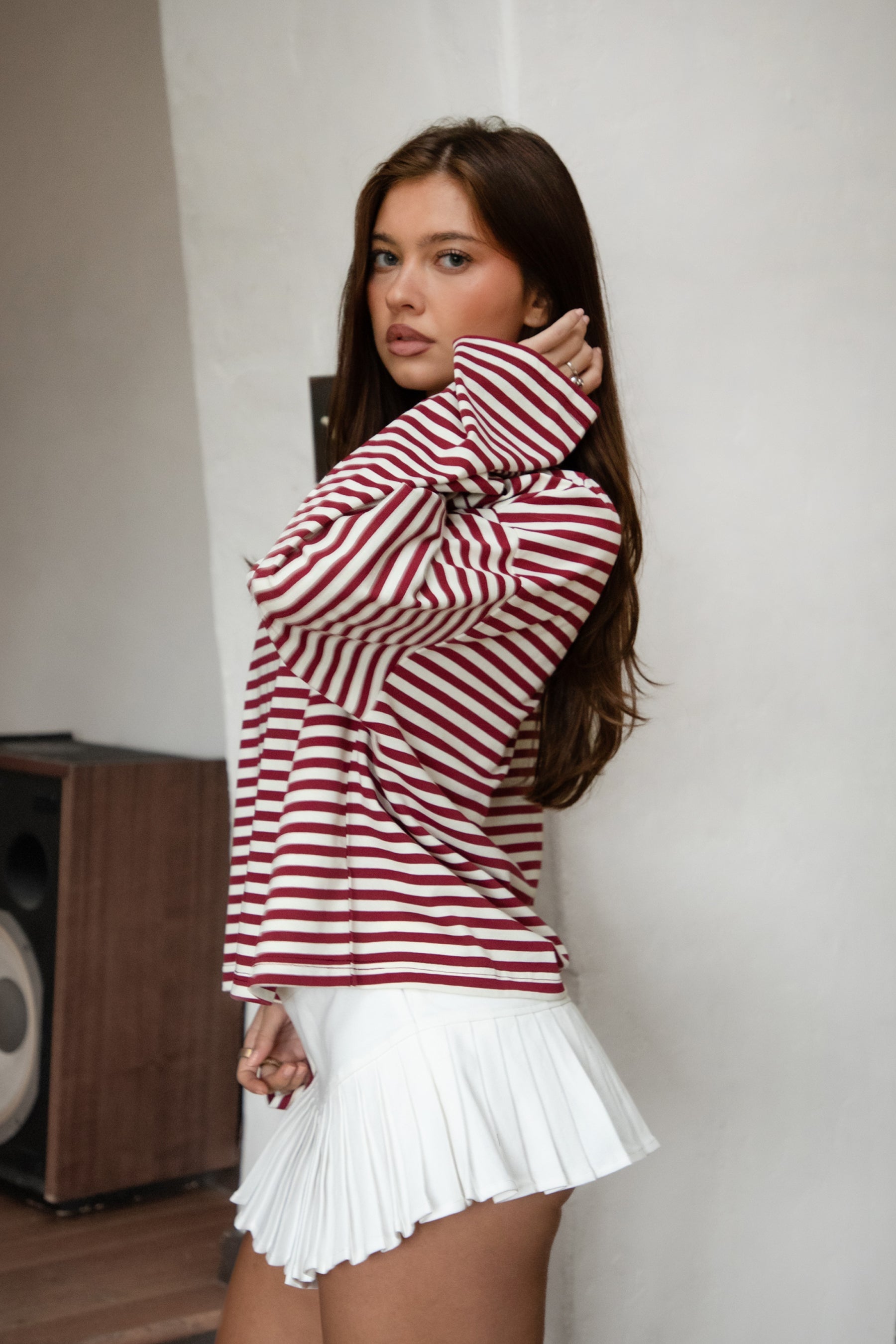 Woman wearing TIC TOC TH31849 MARLOWE striped long sleeve top with a classic crew neckline, relaxed semi-oversized fit, easy drop shoulders, and soft horizontal stripes paired with dark denim jeans in a casual outdoor street setting.
