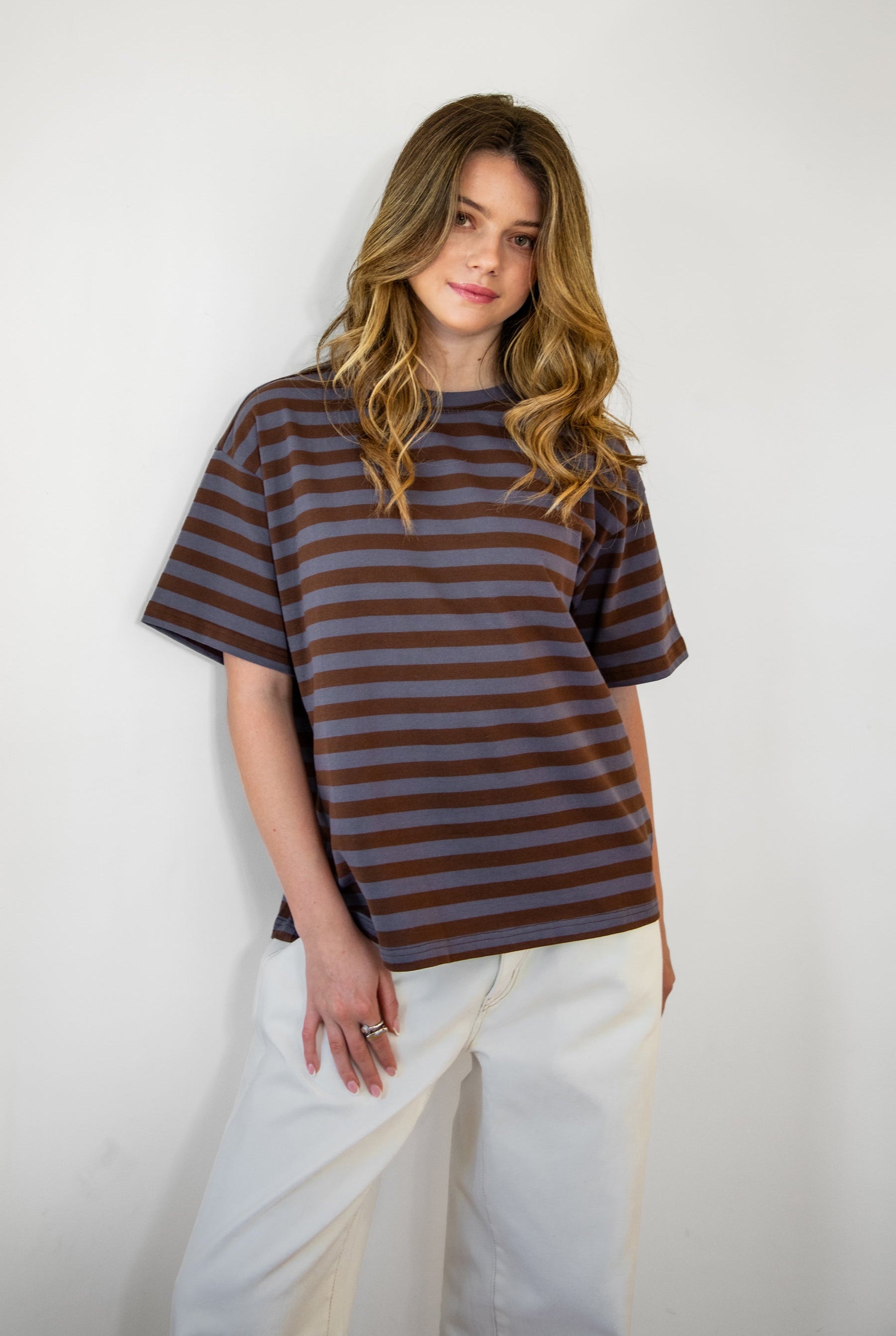 Woman wearing MARIN classic crewneck oversized striped short sleeve top featuring a timeless crew neckline, relaxed oversized fit, drop shoulder sleeves, soft horizontal stripe pattern, breathable 100% cotton fabric, and clean straight hem for everyday casual styling.