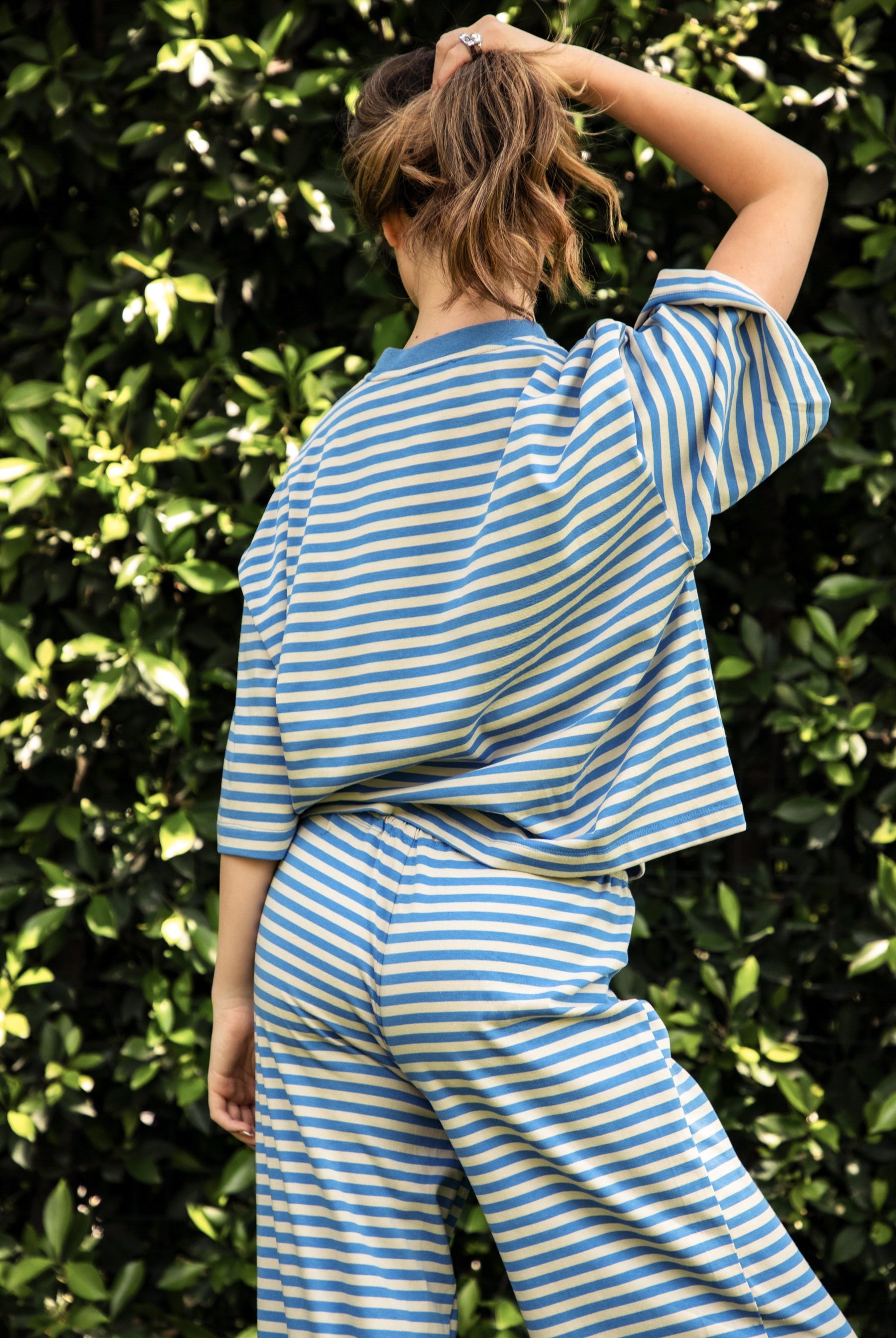 Woman wearing MARLOWE classic crewneck striped short sleeve top featuring a soft horizontal stripe pattern, relaxed semi oversized fit, drop shoulder short sleeves, lightweight stretch cotton blend, and clean straight hemline for casual lounge and coastal styling.
