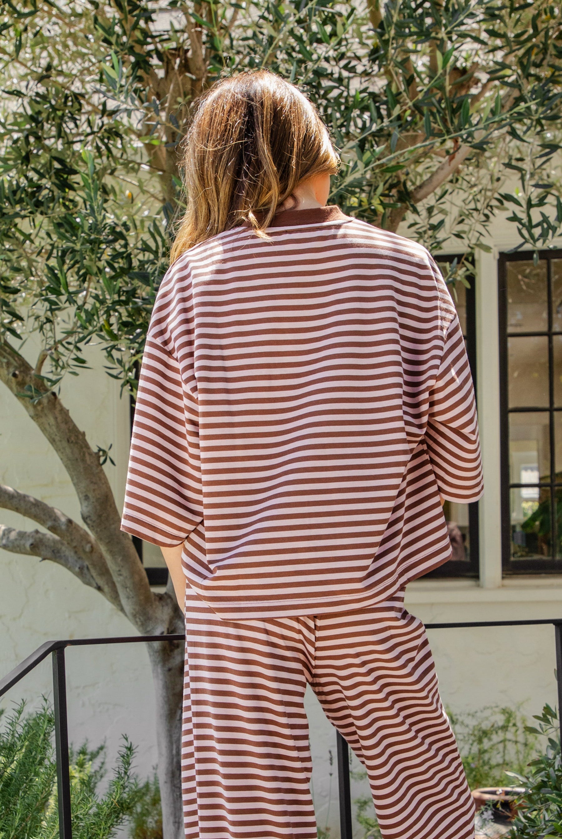 Woman wearing MARLOWE classic crewneck striped short sleeve top featuring a soft horizontal stripe pattern, relaxed semi oversized fit, drop shoulder short sleeves, lightweight stretch cotton blend, and clean straight hemline for casual lounge and coastal styling.