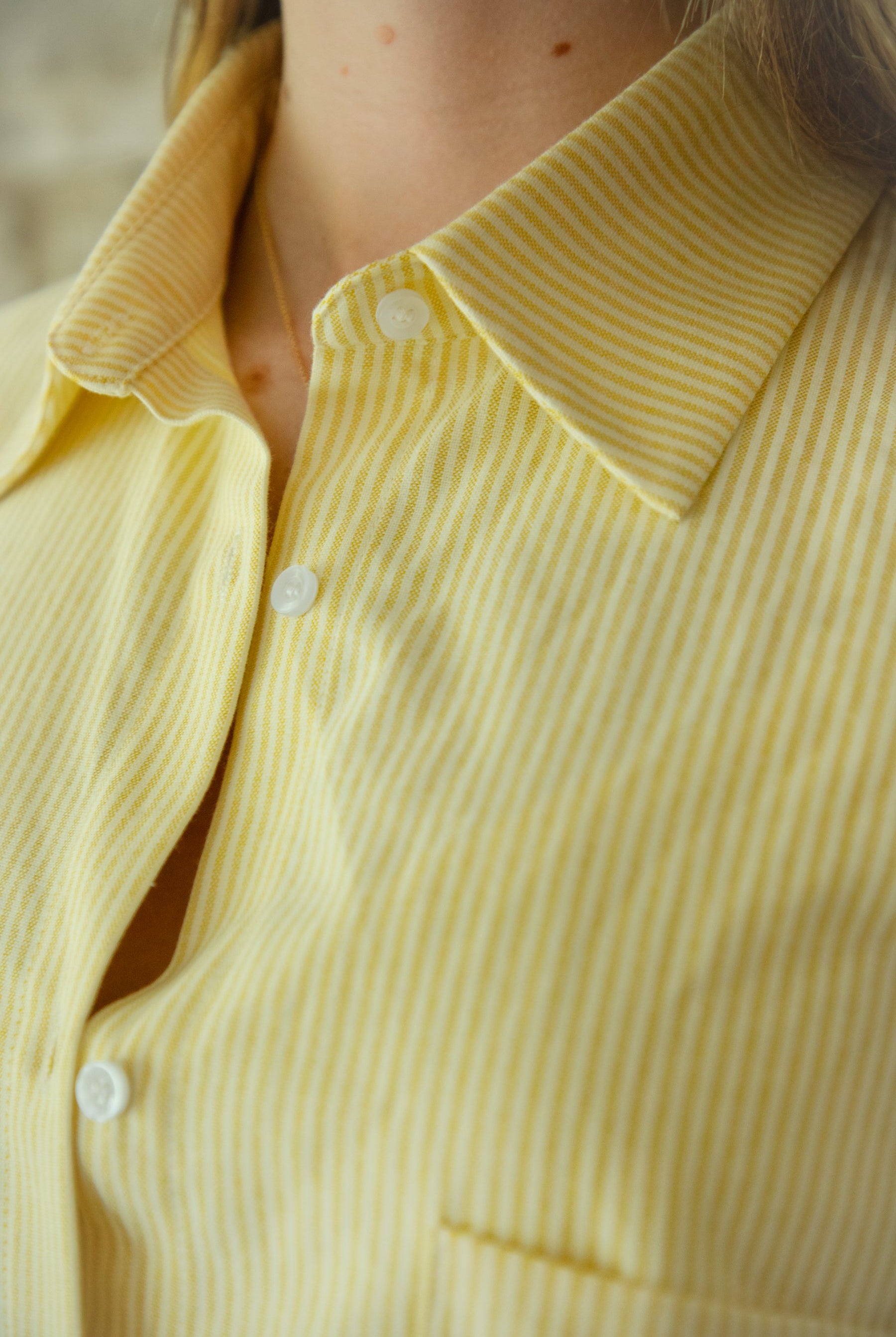 Woman wearing BLAIRE stripe oversized button down shirt featuring classic stripe oxford fabric, relaxed oversized silhouette, collared neckline, full front button closure, dropped shoulders, long sleeves with button cuffs, and functional chest pocket for effortless layering.