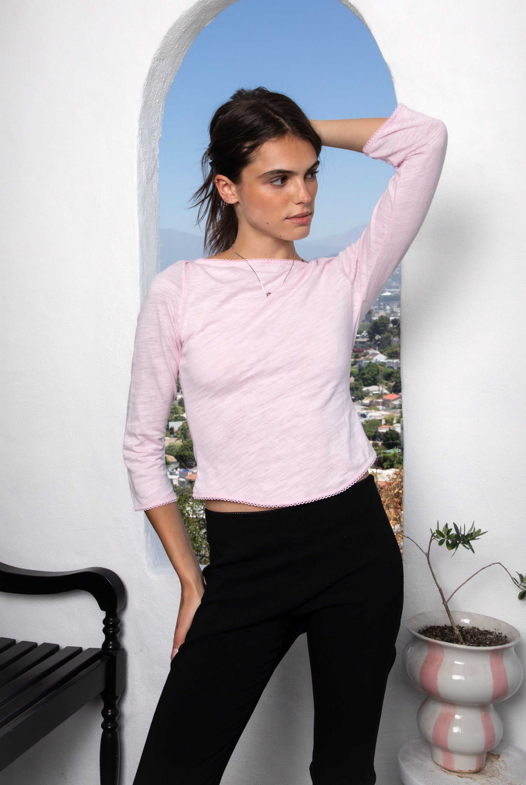 Woman wearing LUMA cotton rib three quarter sleeve boat neck top featuring soft cotton slub jersey, lightweight breathable feel, classic boat neckline, delicate picot trim, three quarter sleeves with matching cuff trim, picot trim hem, relaxed slim fit, and subtle curved hem.