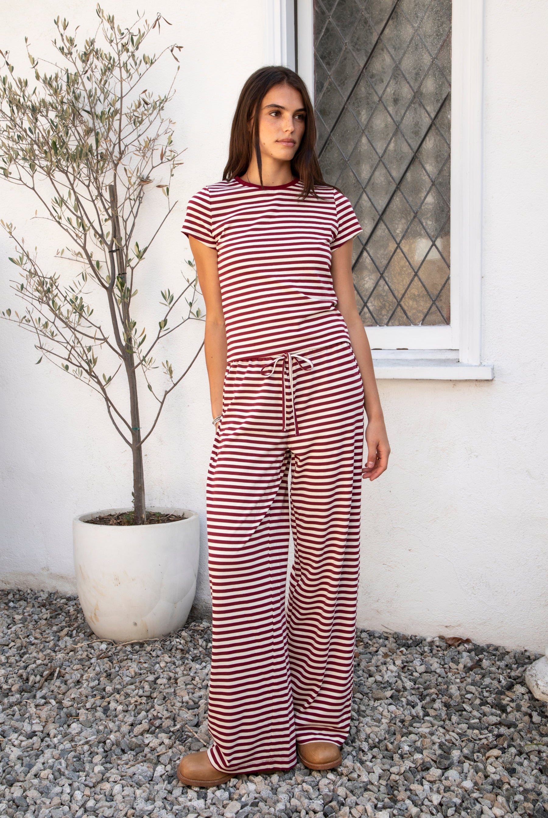 Woman wearing MARLOWE classic crewneck stripe short sleeve t-shirt featuring soft cotton blend fabric, lightweight comfortable feel, timeless striped pattern, classic crew neckline, short sleeves, relaxed slim fit, and effortless essential design for layering or everyday styling.