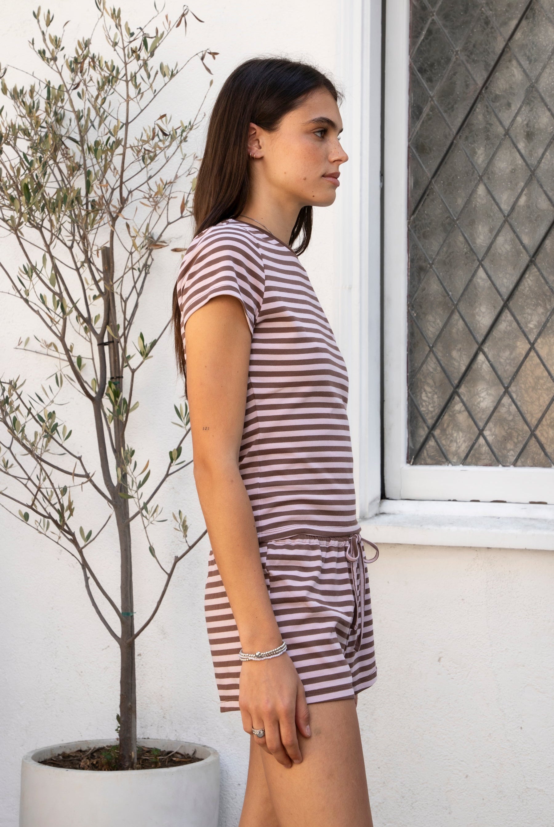 Woman wearing MARLOWE classic crewneck stripe short sleeve t-shirt featuring soft cotton blend fabric, lightweight comfortable feel, timeless striped pattern, classic crew neckline, short sleeves, relaxed slim fit, and effortless essential design for layering or everyday styling.