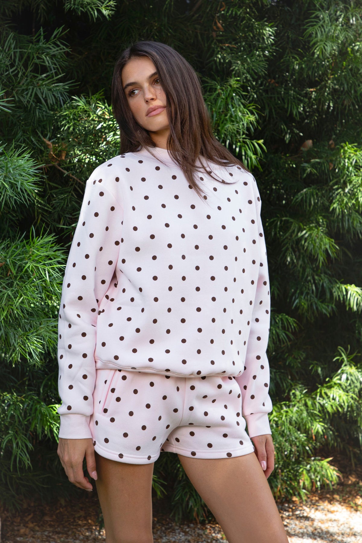 Woman wearing PIPPA polka dot plush fleece mock neck sweatshirt featuring soft cotton blend fleece fabric, allover polka dot print, classic crew neckline with ribbed trim, relaxed silhouette, long sleeves with dropped shoulders, ribbed cuffs and hem, and cozy construction designed to pair with the matching PIPPA shorts.