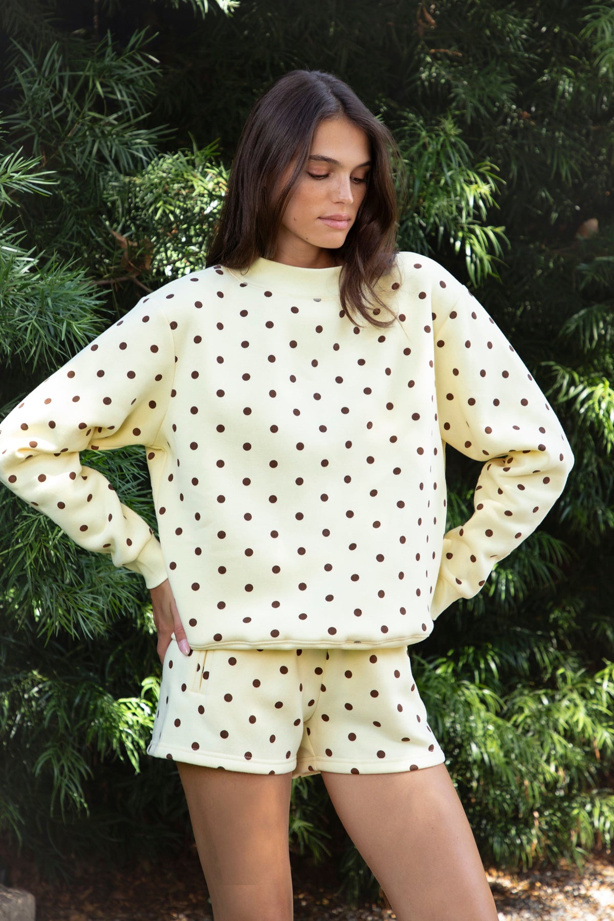 Woman wearing PIPPA polka dot plush fleece mock neck sweatshirt featuring soft cotton blend fleece fabric, allover polka dot print, classic crew neckline with ribbed trim, relaxed silhouette, long sleeves with dropped shoulders, ribbed cuffs and hem, and cozy construction designed to pair with the matching PIPPA shorts.