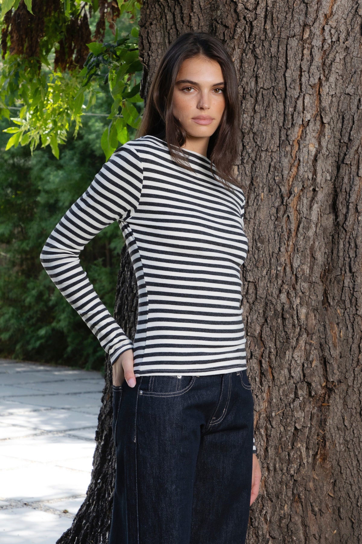 Woman wearing ROSLYN striped boat neck long sleeve top featuring soft brushed cotton stretch jersey fabric, classic horizontal stripe pattern, wide boat neckline that can be styled on or slightly off the shoulder, fitted silhouette, slim full length sleeves, and hip length hem for easy everyday styling.