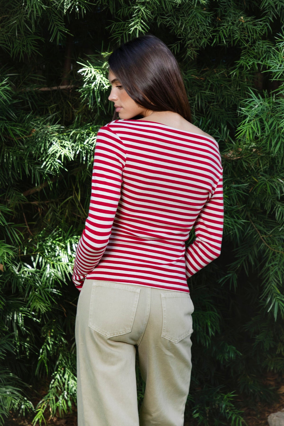 Woman wearing ROSLYN striped boat neck long sleeve top featuring soft brushed cotton stretch jersey fabric, classic horizontal stripe pattern, wide boat neckline that can be styled on or slightly off the shoulder, fitted silhouette, slim full length sleeves, and hip length hem for easy everyday styling.