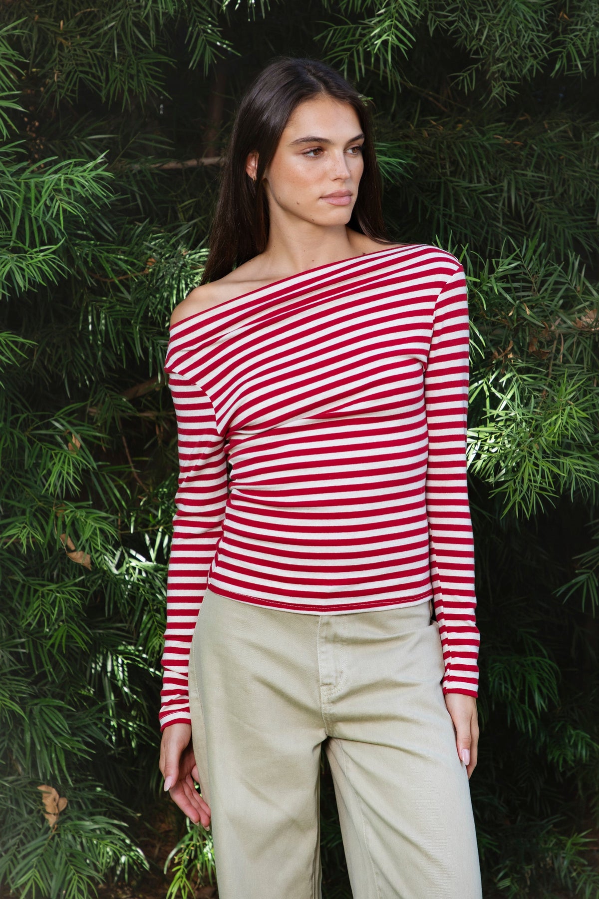 Woman wearing ROSLYN striped boat neck long sleeve top featuring soft brushed cotton stretch jersey fabric, classic horizontal stripe pattern, wide boat neckline that can be styled on or slightly off the shoulder, fitted silhouette, slim full length sleeves, and hip length hem for easy everyday styling.