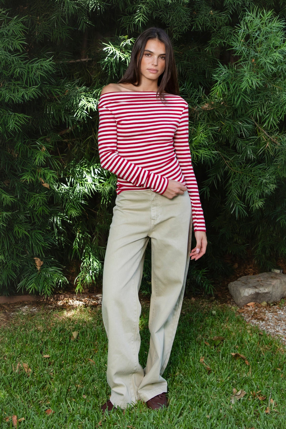 Woman wearing ROSLYN striped boat neck long sleeve top featuring soft brushed cotton stretch jersey fabric, classic horizontal stripe pattern, wide boat neckline that can be styled on or slightly off the shoulder, fitted silhouette, slim full length sleeves, and hip length hem for easy everyday styling.
