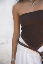Woman wearing TIC TOC WREN Brown Stretch Lace Scarf Top with whit emaxi skirt