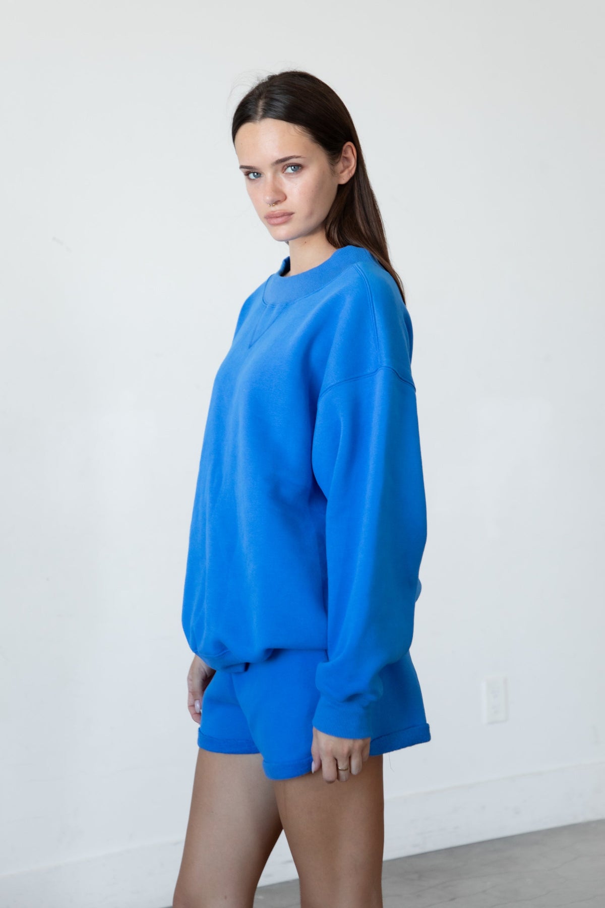 Woman wearing LANI mock neck cloud fleece sweatshirt featuring soft cotton blend cloud fleece fabric, ribbed mock neckline, relaxed oversized fit, dropped shoulder design, long sleeves with ribbed cuffs, triangle stitch detail at center front, and ribbed hem for a cozy comfortable finish.