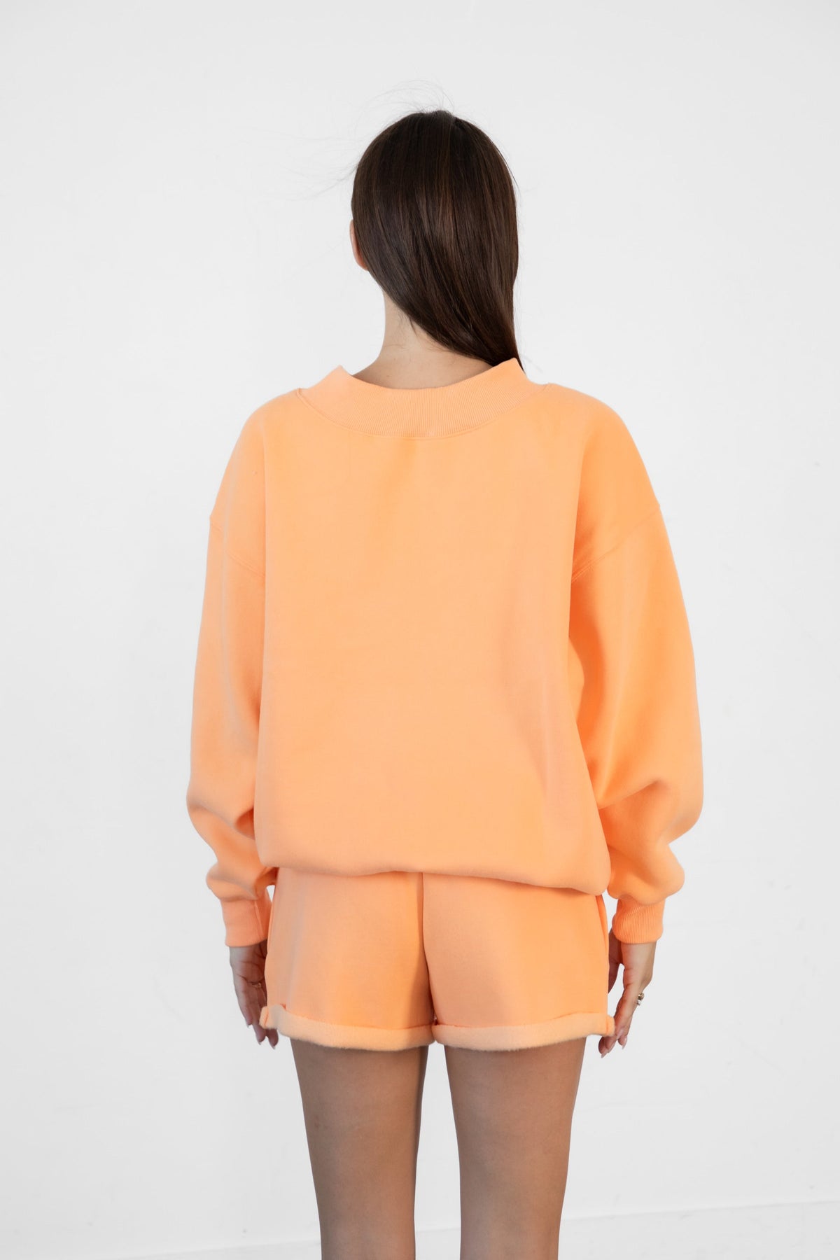 Woman wearing LANI mock neck cloud fleece sweatshirt featuring soft cotton blend cloud fleece fabric, ribbed mock neckline, relaxed oversized fit, dropped shoulder design, long sleeves with ribbed cuffs, triangle stitch detail at center front, and ribbed hem for a cozy comfortable finish.