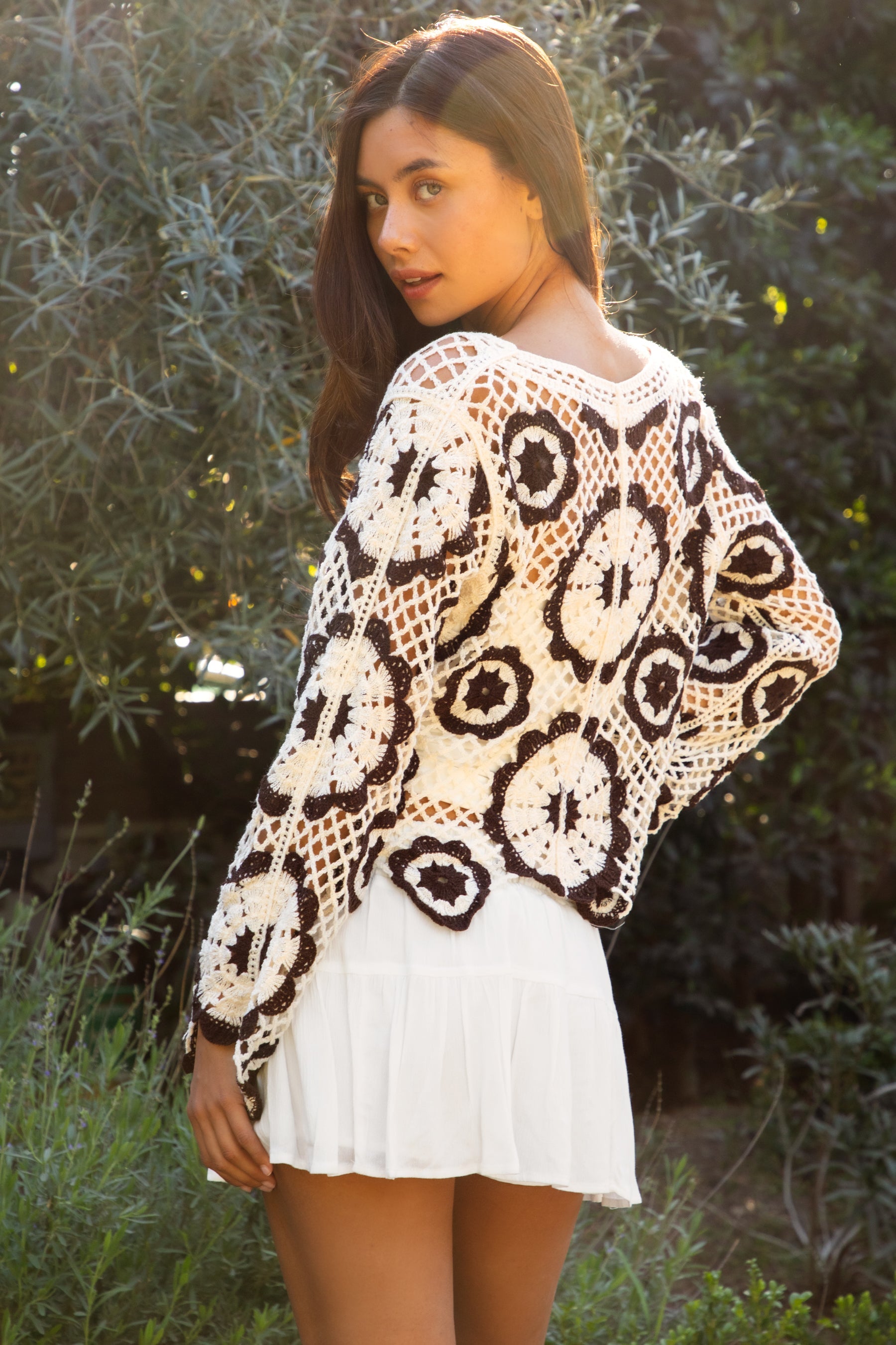 Woman wearing TIC TOC TL31962-SOLANDRA SOLANDRA crochet long sleeve cover up top featuring an open crochet mandala flower pattern in contrast cream and brown circular design, wide round neckline, relaxed easy fit silhouette, and long bell sleeves with lightweight open knit texture, styled over a simple bralette and bottoms for a boho festival and resort-ready look.