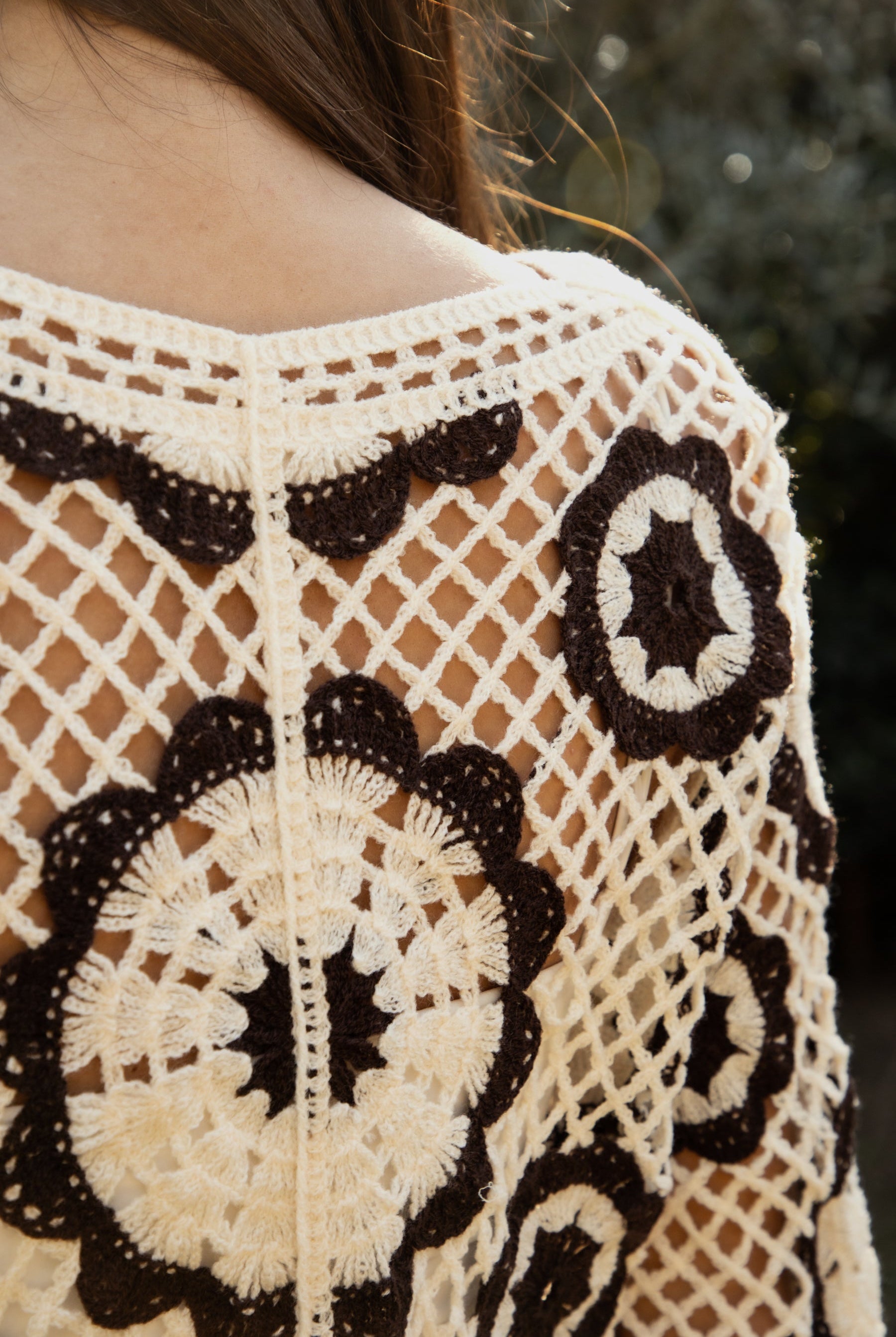 Woman wearing TIC TOC TL31962-SOLANDRA SOLANDRA crochet long sleeve cover up top featuring an open crochet mandala flower pattern in contrast cream and brown circular design, wide round neckline, relaxed easy fit silhouette, and long bell sleeves with lightweight open knit texture, styled over a simple bralette and bottoms for a boho festival and resort-ready look.