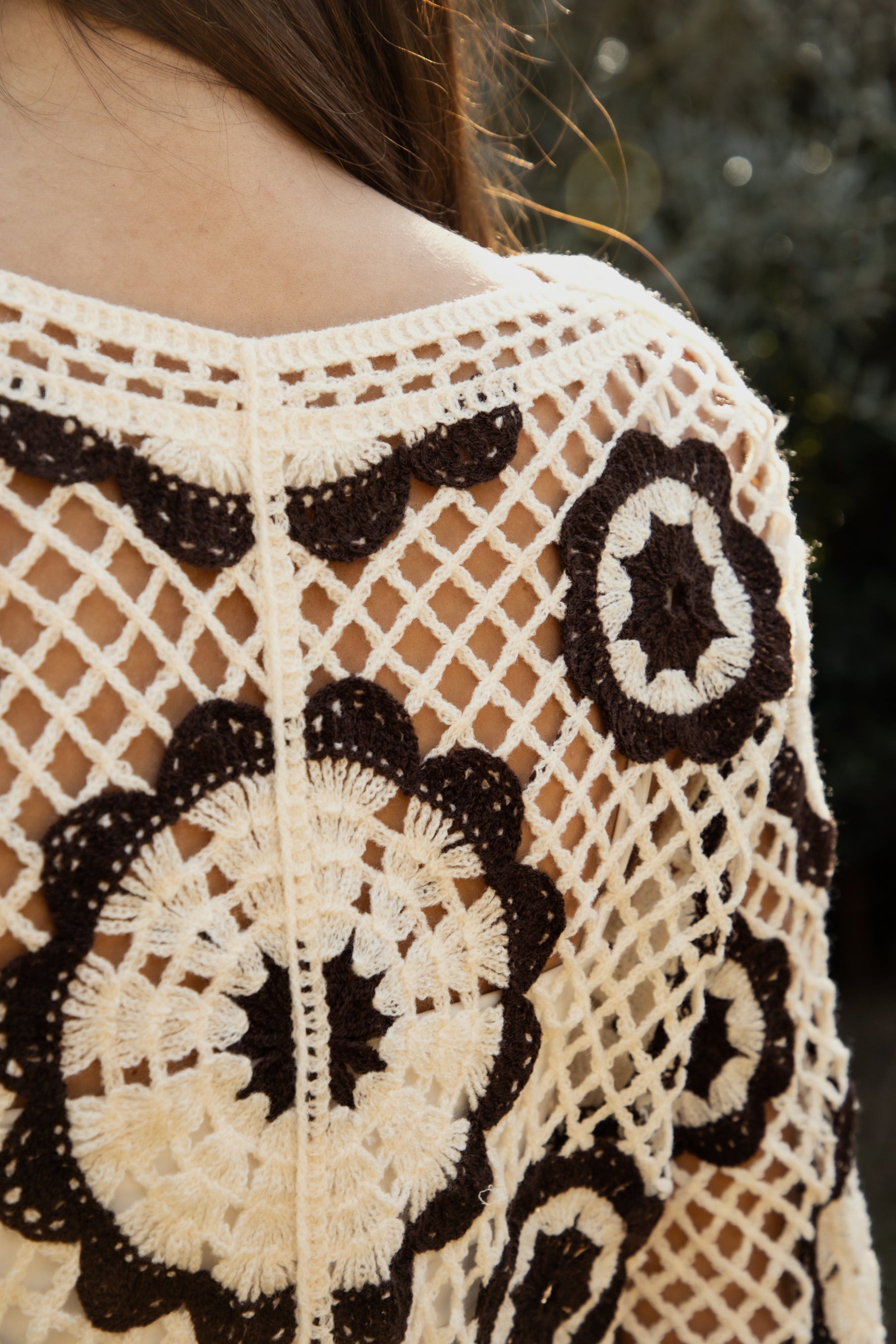 Woman wearing TIC TOC TL31962-SOLANDRA SOLANDRA crochet long sleeve cover up top featuring an open crochet mandala flower pattern in contrast cream and brown circular design, wide round neckline, relaxed easy fit silhouette, and long bell sleeves with lightweight open knit texture, styled over a simple bralette and bottoms for a boho festival and resort-ready look.