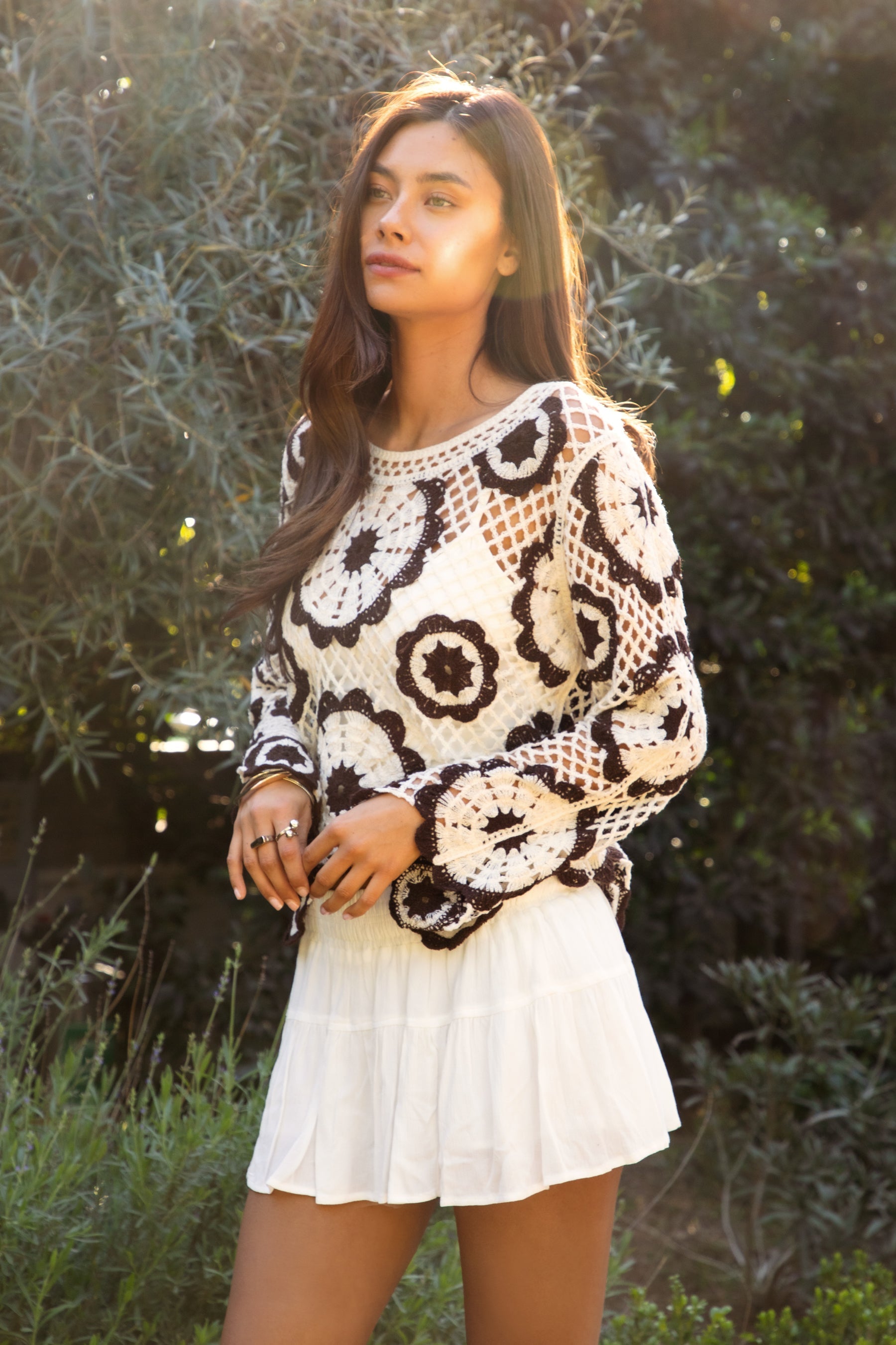 Woman wearing TIC TOC TL31962-SOLANDRA SOLANDRA crochet long sleeve cover up top featuring an open crochet mandala flower pattern in contrast cream and brown circular design, wide round neckline, relaxed easy fit silhouette, and long bell sleeves with lightweight open knit texture, styled over a simple bralette and bottoms for a boho festival and resort-ready look.