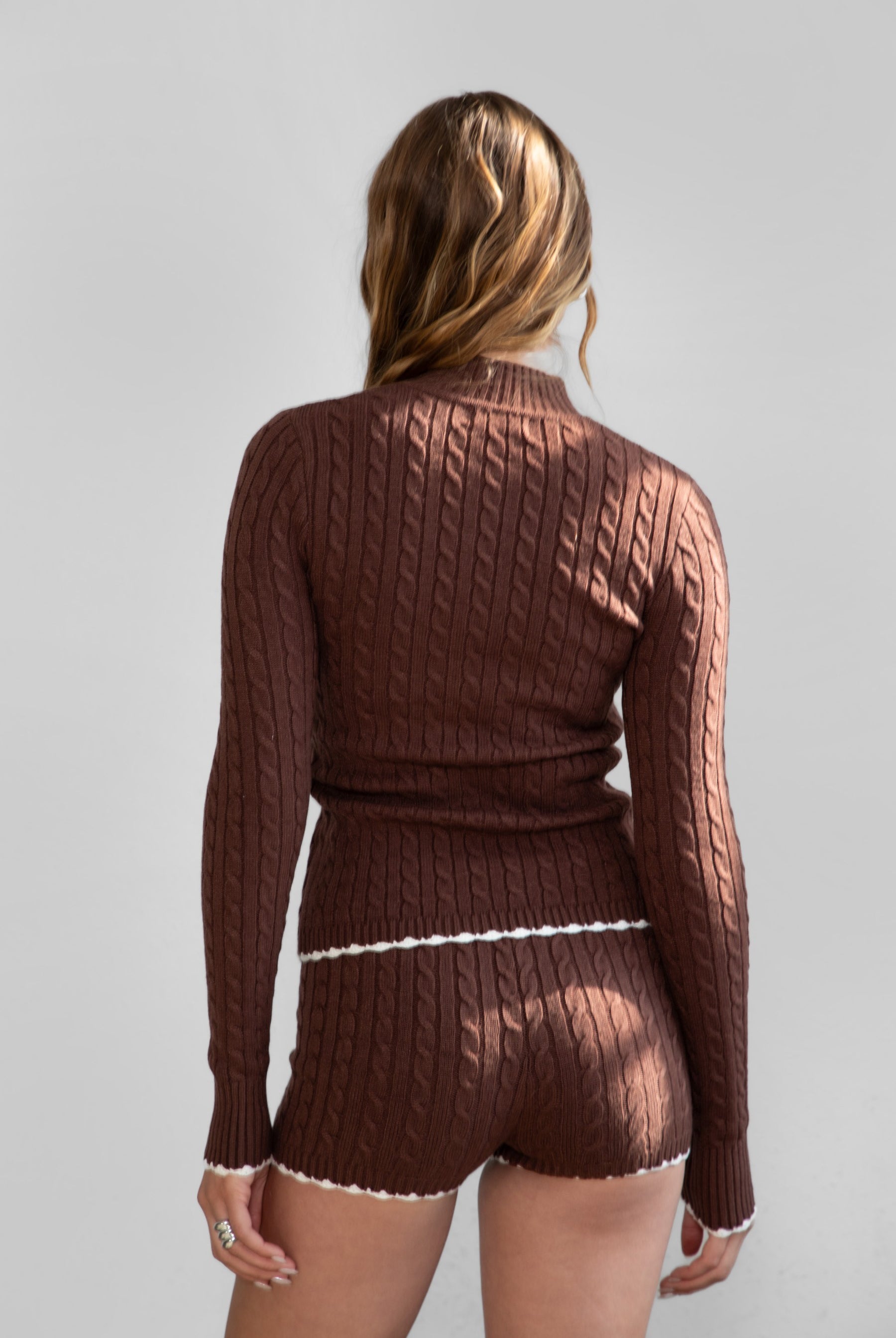 TIC TOC TPC31027 CLINE Cable Knit Two-Piece Lounge Short Set in brown and blush. Features a zip-up cropped sweater with a high mock neck, ribbed contrast trim, and matching mid-rise shorties.